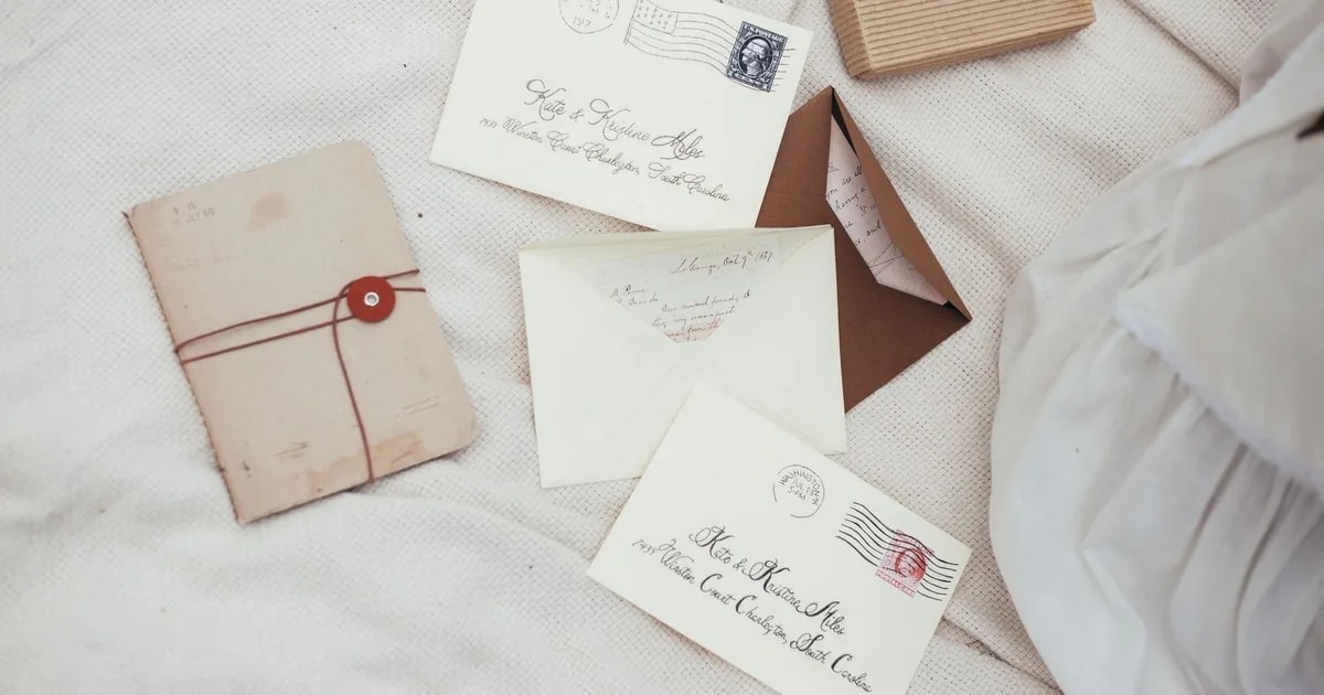 Wedding invitation envelopes addressed in calligraphy with full guest names and a spelled-out address