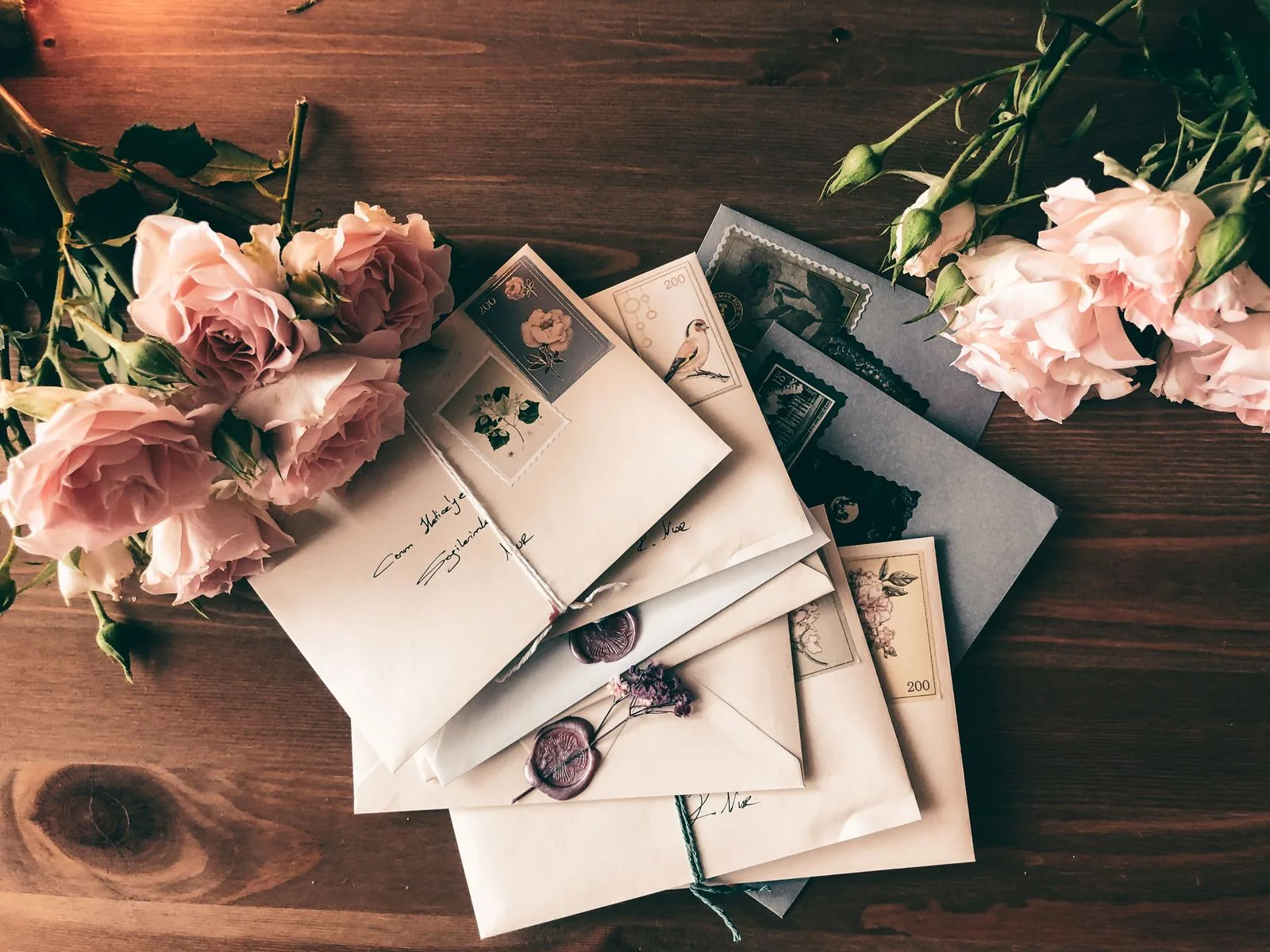 Stack of handwritten wedding envelopes with vintage stamps and wax seals