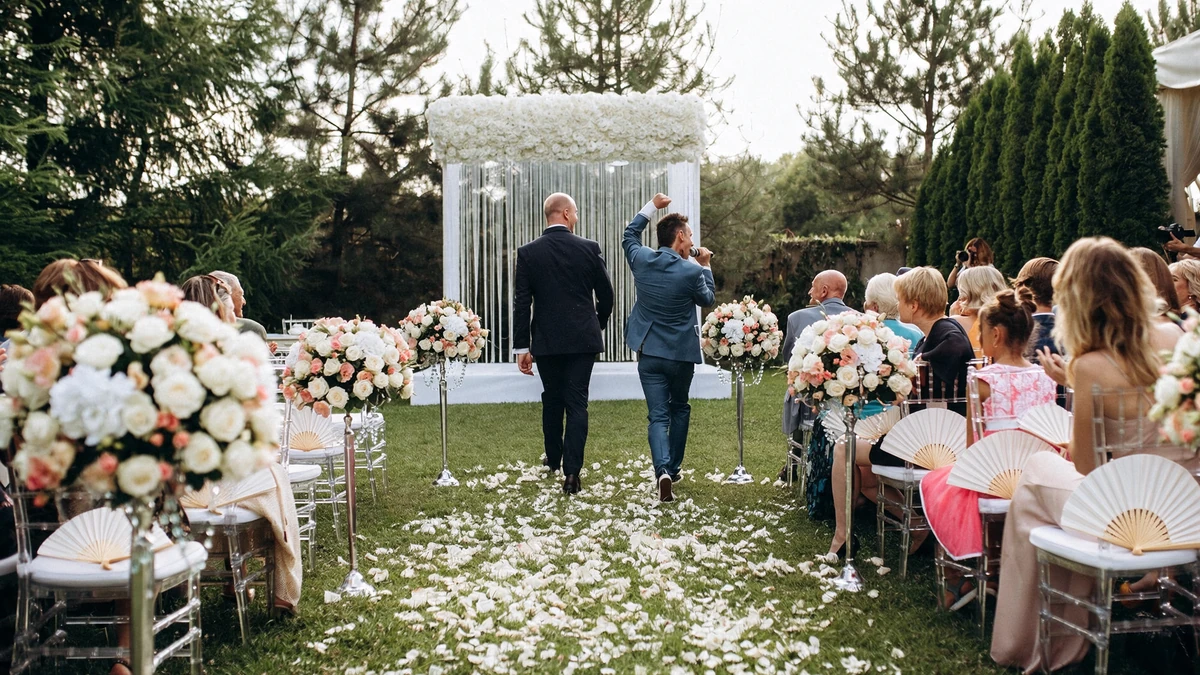Paper fan programs resting on guest chairs at a sunny outdoor wedding ceremony as the aisle is walked