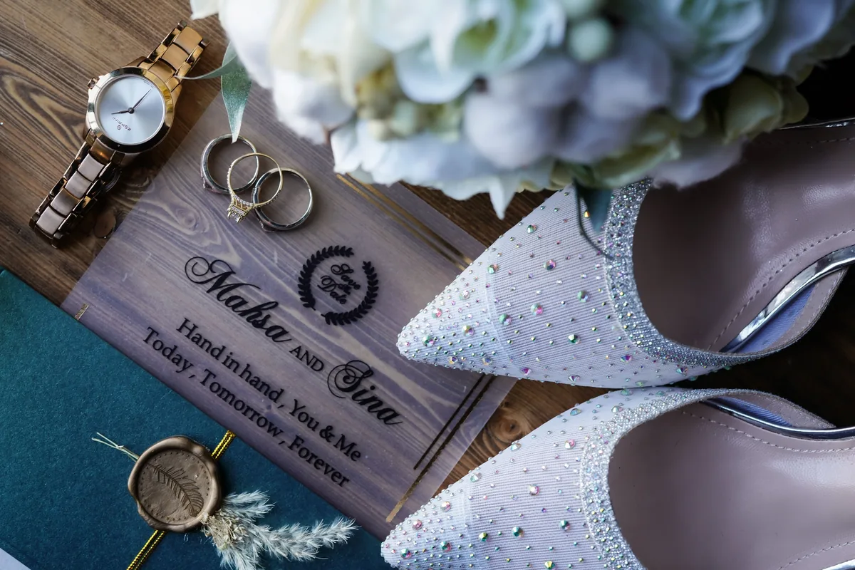 Engraved wooden save the date sign with wedding rings and bridal shoes, illustrating when couples should send save the dates before the wedding
