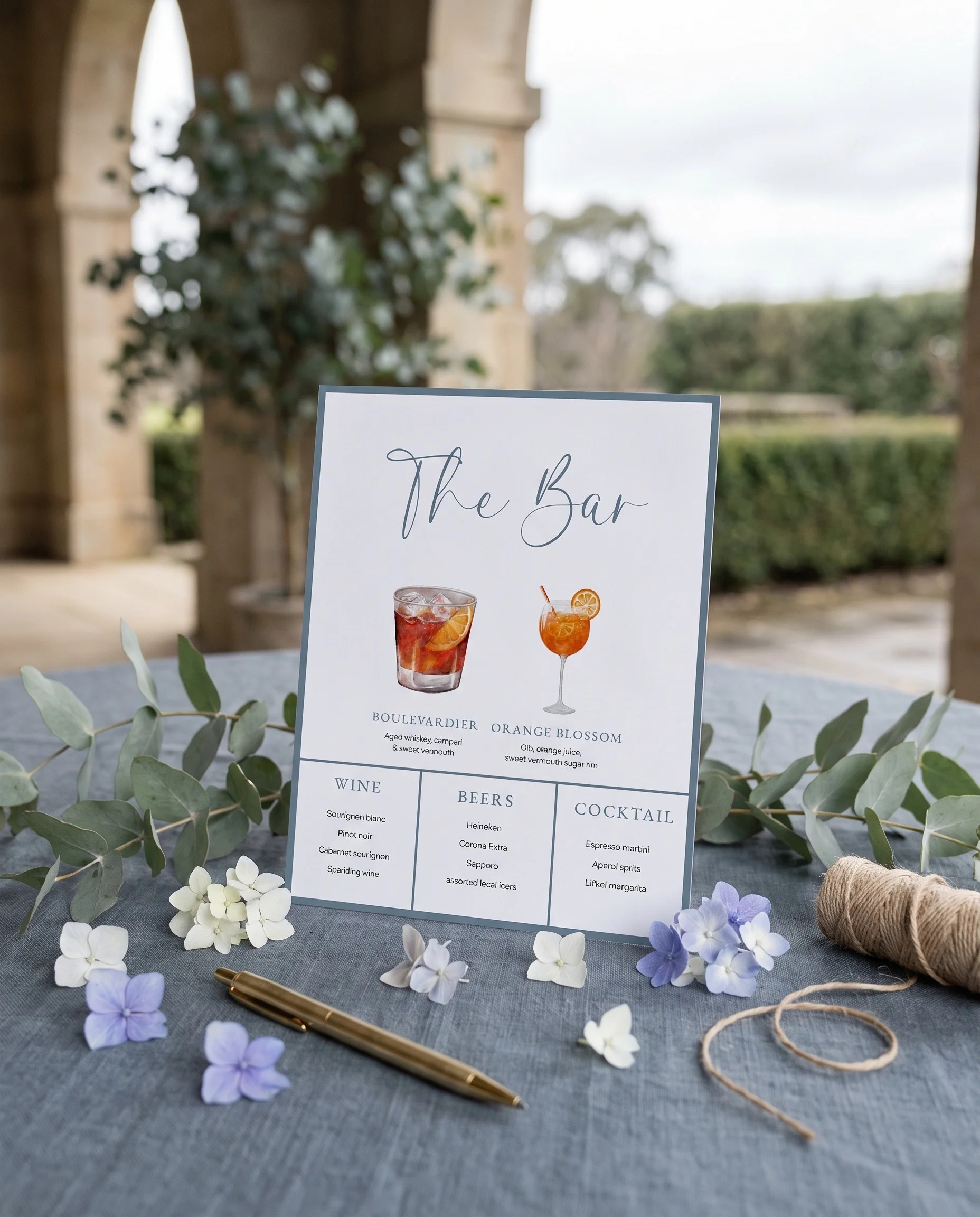 Arrow Crest — bar menu page displayed upright in a styled setting under soft natural light, wedding bar sign.