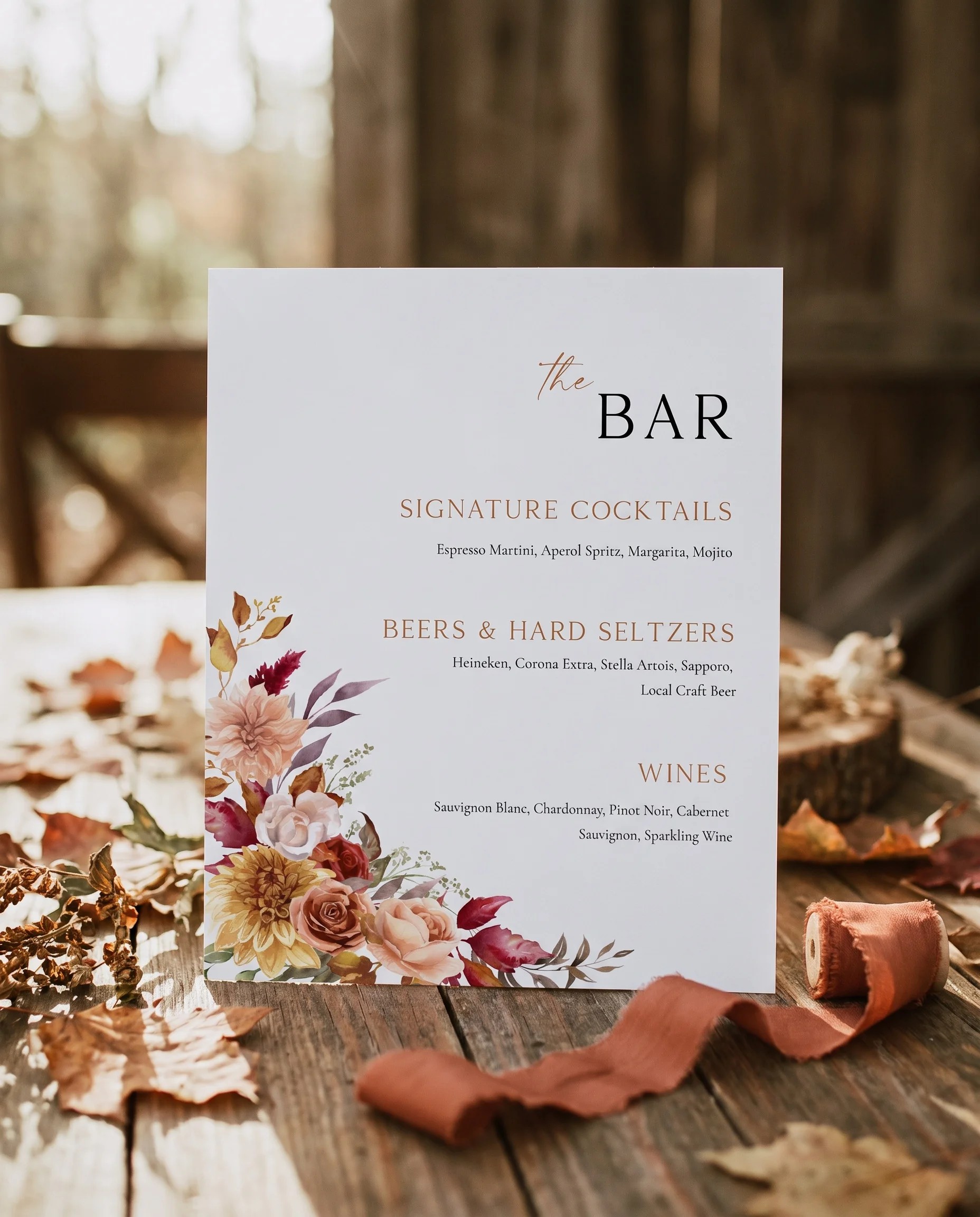 Autumn Bloom — bar menu page displayed upright in a styled setting under soft natural light, wedding bar sign.