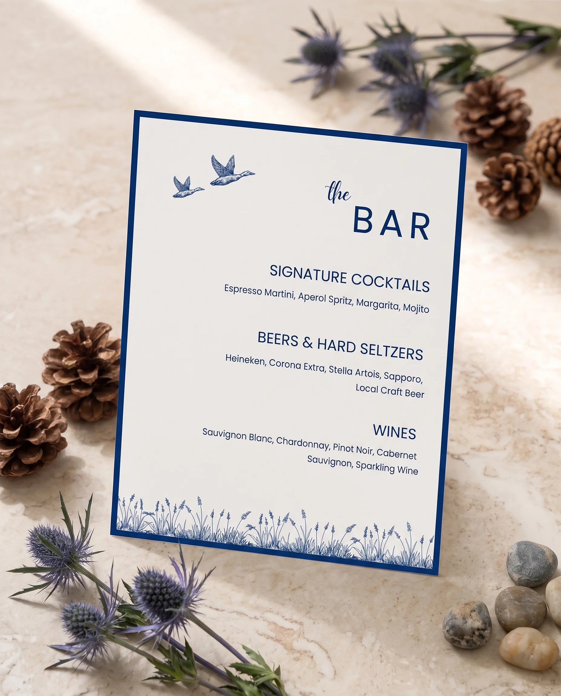 Blue Range — bar menu page displayed upright in a styled setting under soft natural light, slight overhead angle, wedding bar sign.