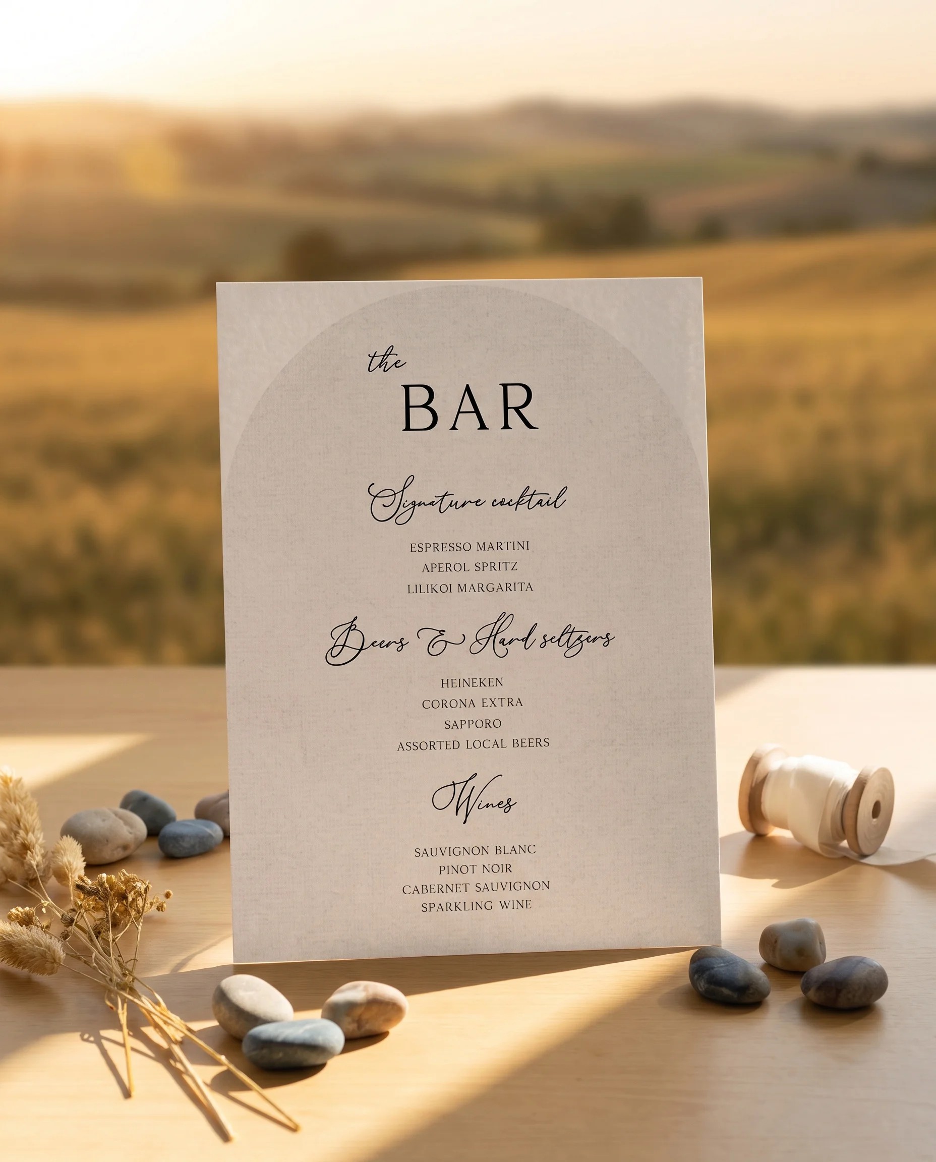 Halo Arch — bar menu displayed upright on premium editorial paper under soft natural light at a slight overhead angle, wedding bar sign.