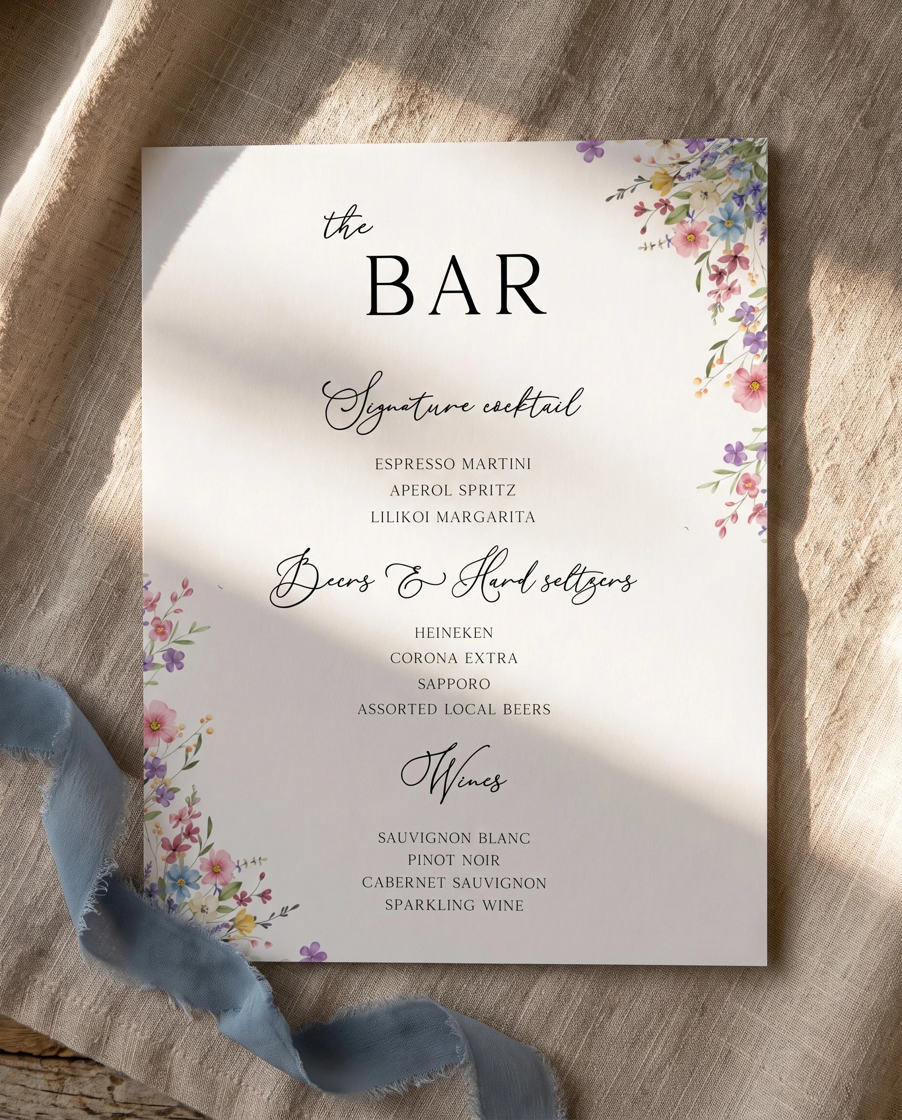 Meadowlark — flat lay of the single-page bar menu on premium editorial paper under soft natural light, wedding bar menu.