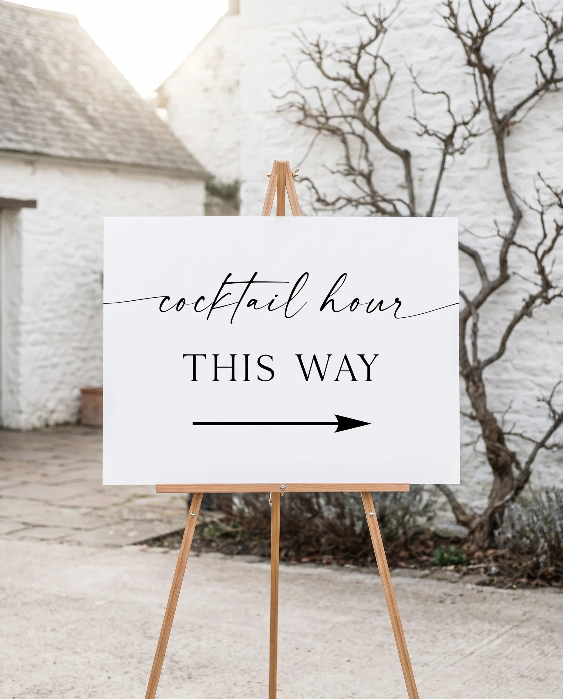 Liminal wedding cocktail hour sign — displayed on an easel under soft natural light with a slight overhead angle, wedding signs.
