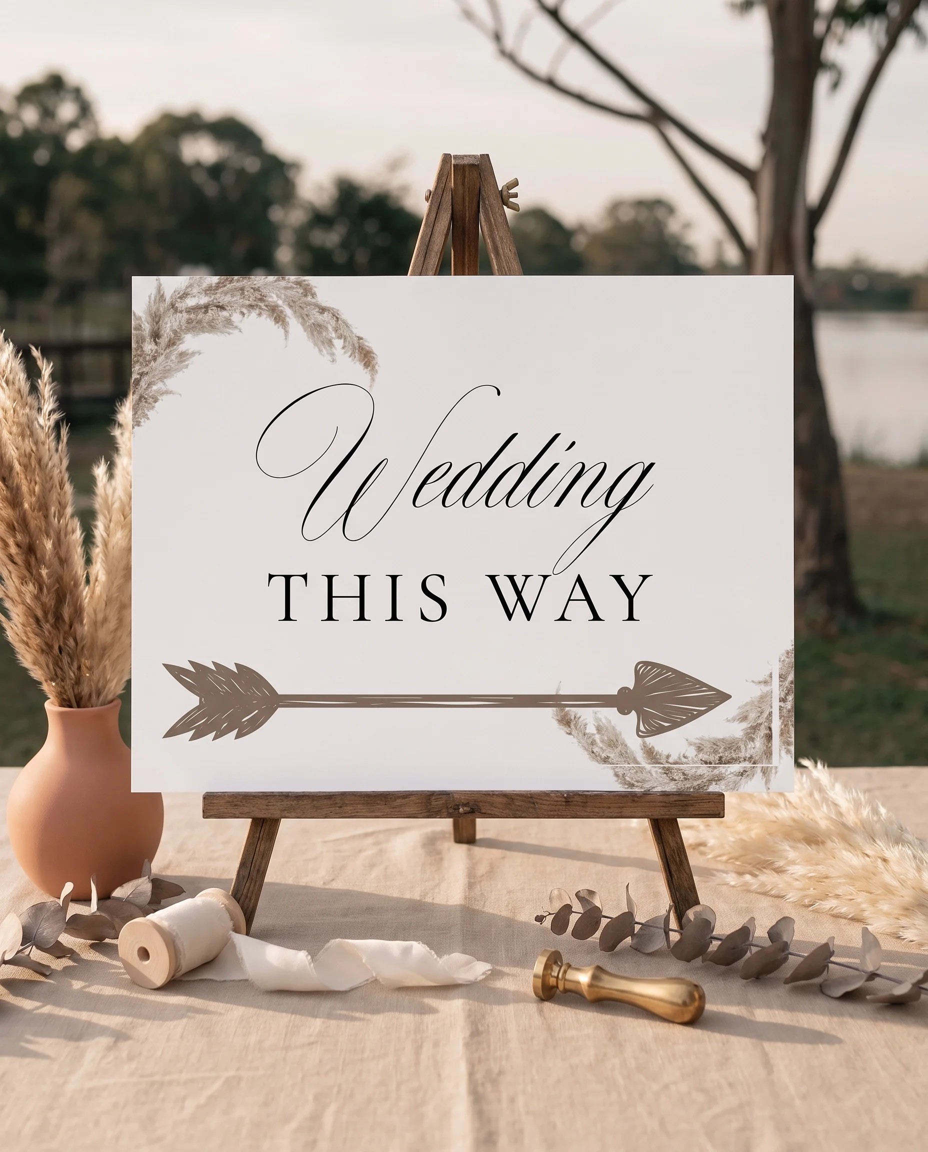 Pampas wedding directional sign — displayed on an easel under soft natural light with a slight overhead angle, wedding signs