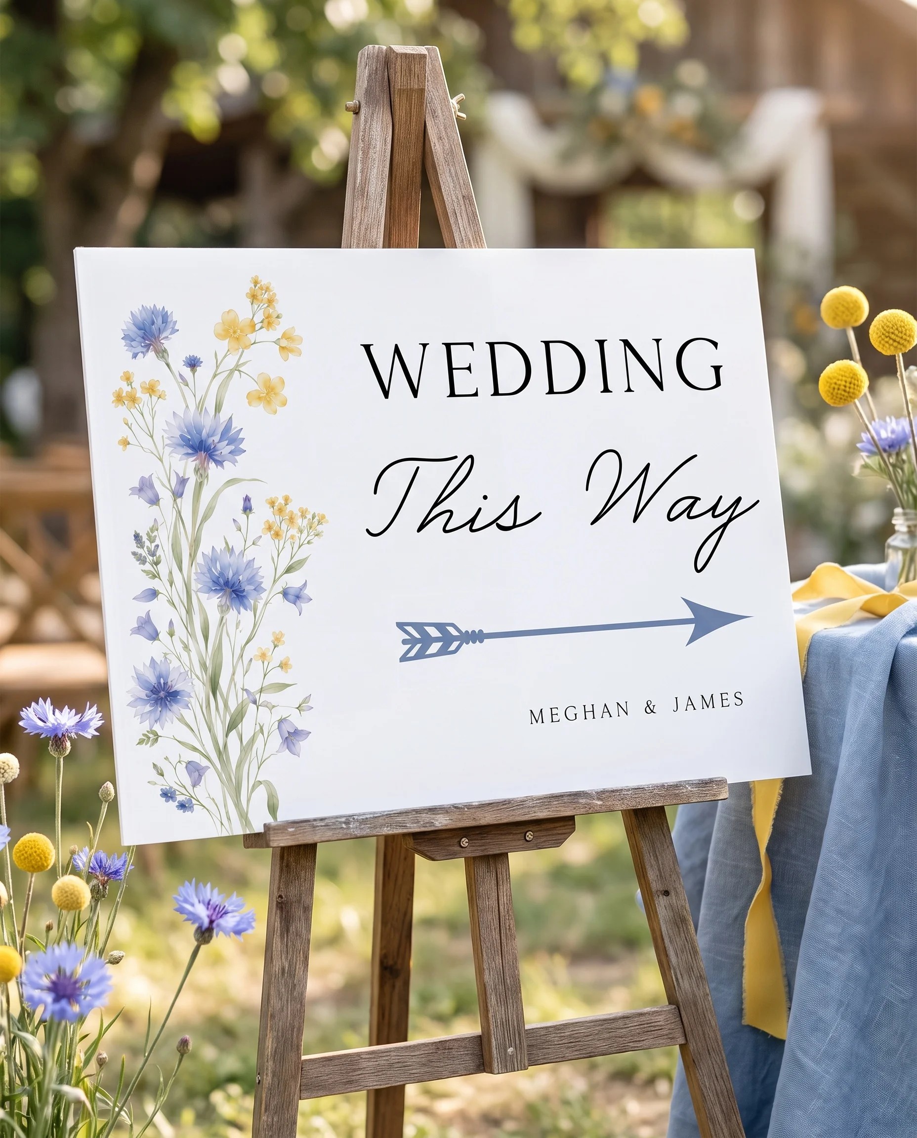 Cornflower wedding directional sign — displayed in a wedding venue setting under soft natural light with a slight overhead angle, wedding signage