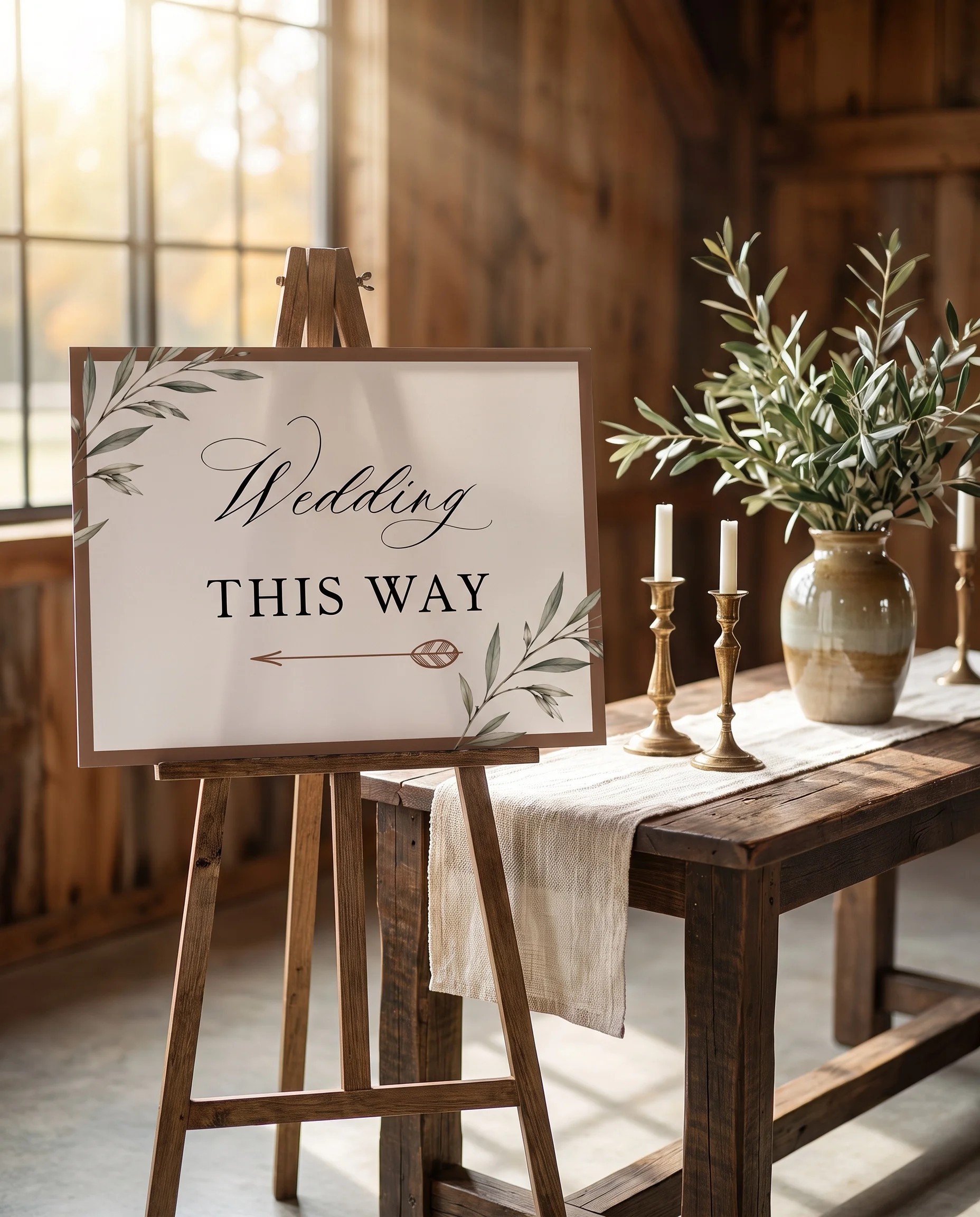 Olive Arc wedding directional sign — shown beside furniture for scale on premium editorial paper in soft natural light, printable wedding signs.