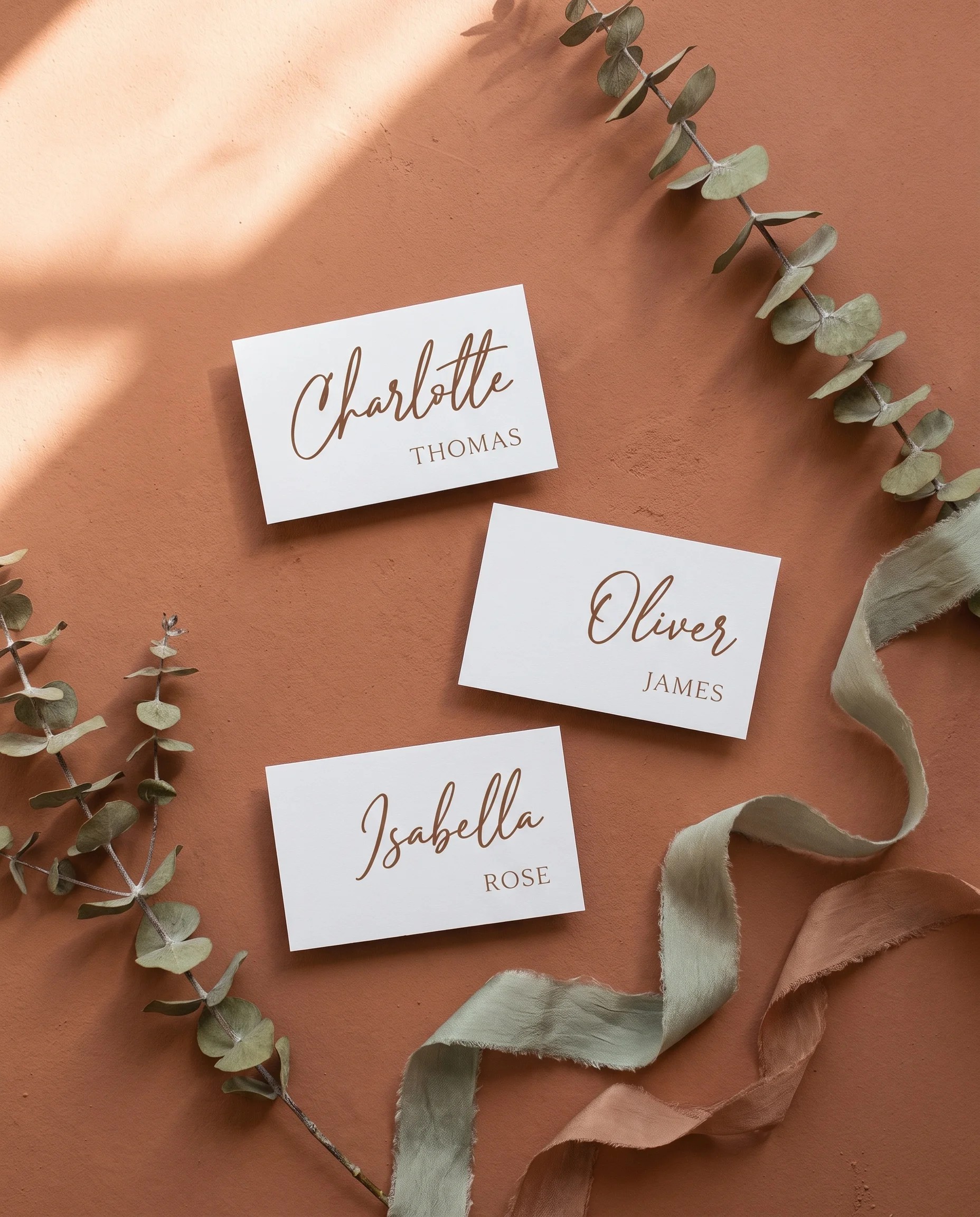 Briar Script wedding place cards — several cards shown flat under soft natural light at a slight overhead angle, wedding place cards.