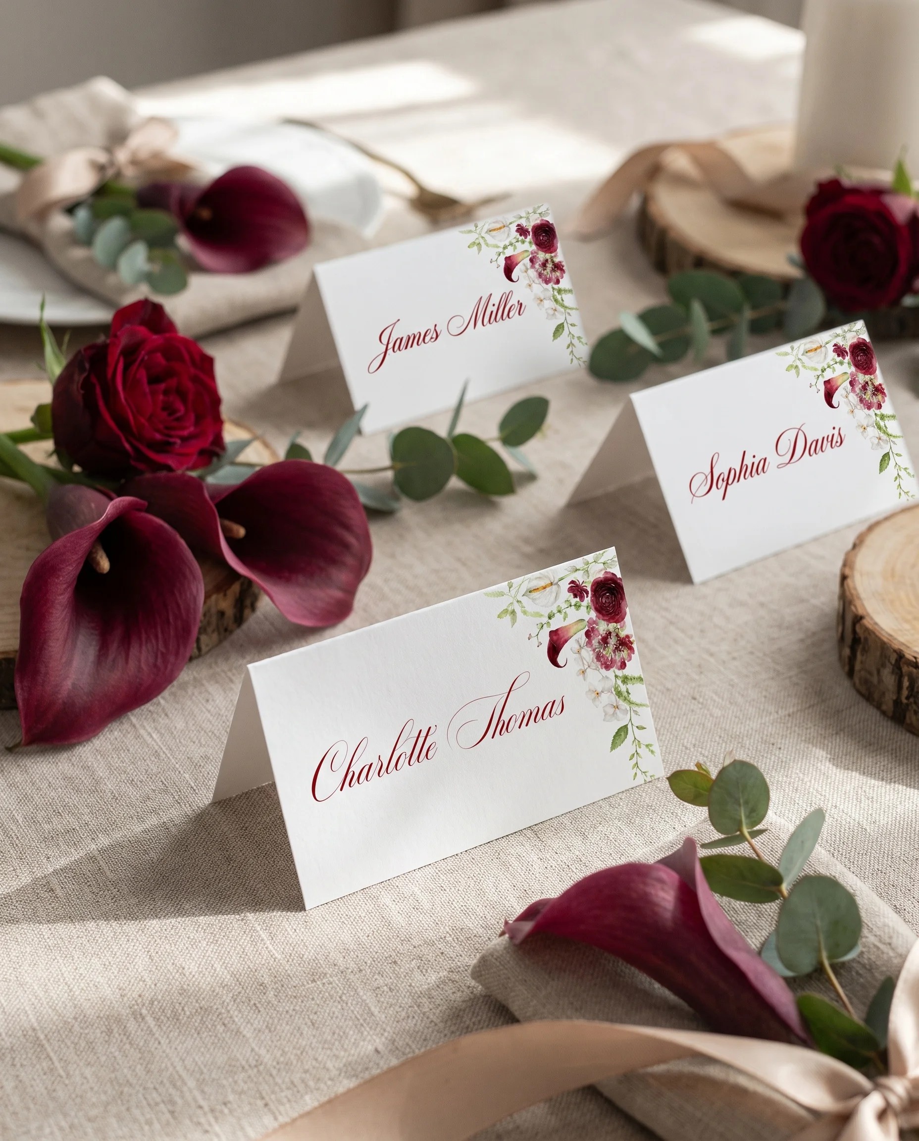 Burgundy Calla wedding place cards — several place cards arranged on a dressed reception table under soft natural light, place card template