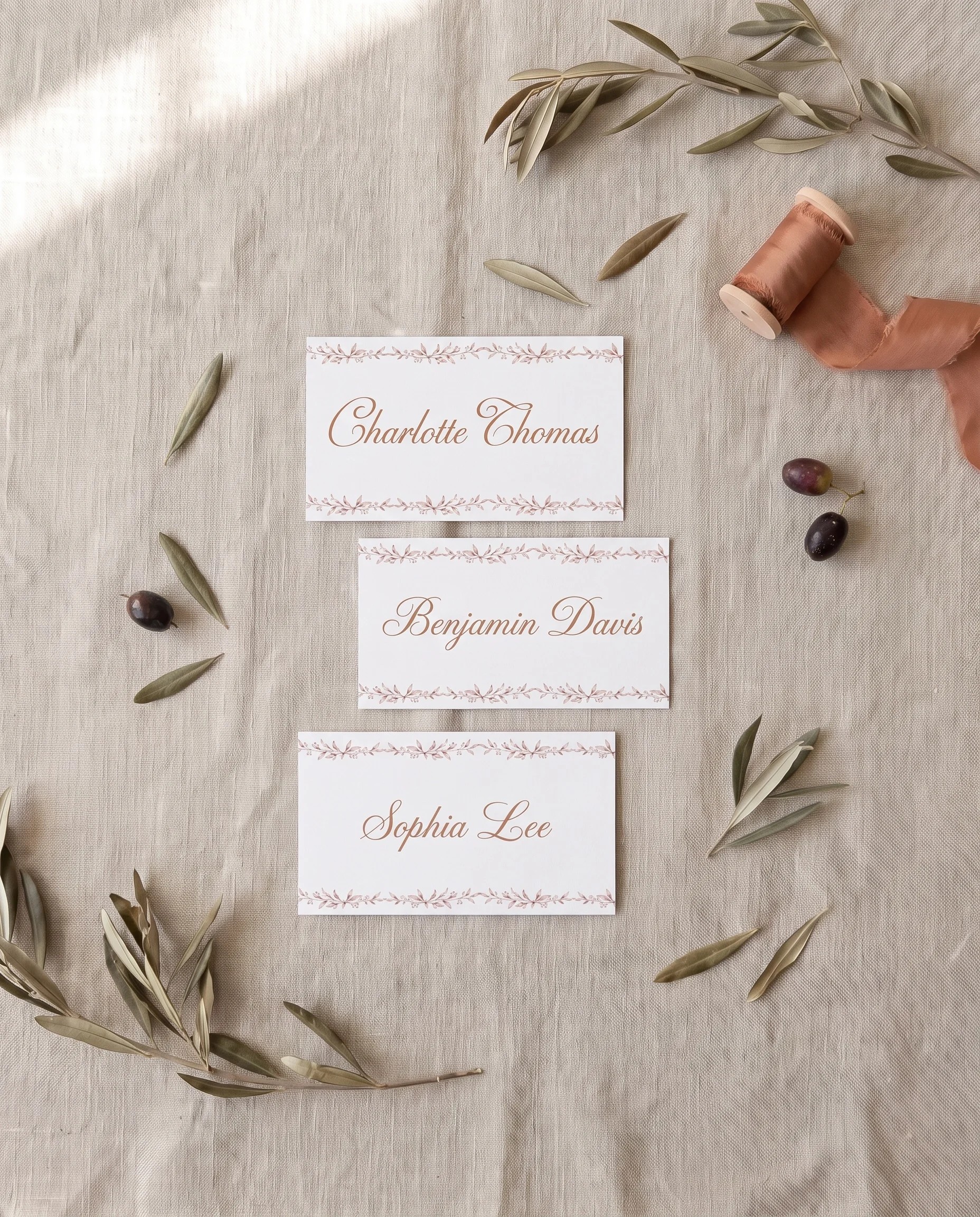 Sepia Sprig wedding place cards — several place cards shown flat under soft natural light, wedding place cards