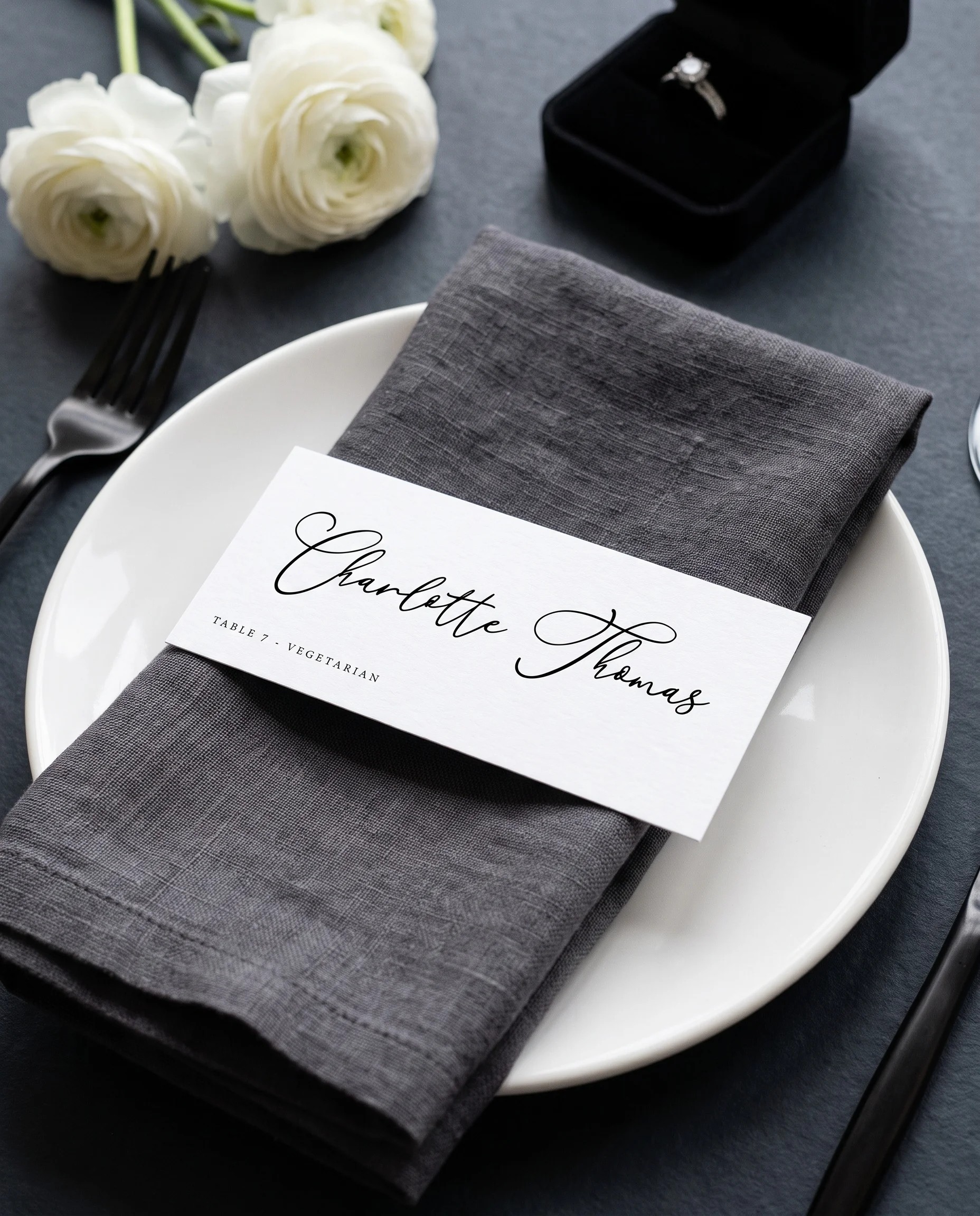 Monochrome wedding place cards — a single card displayed at a set place setting under soft natural light, wedding name cards.