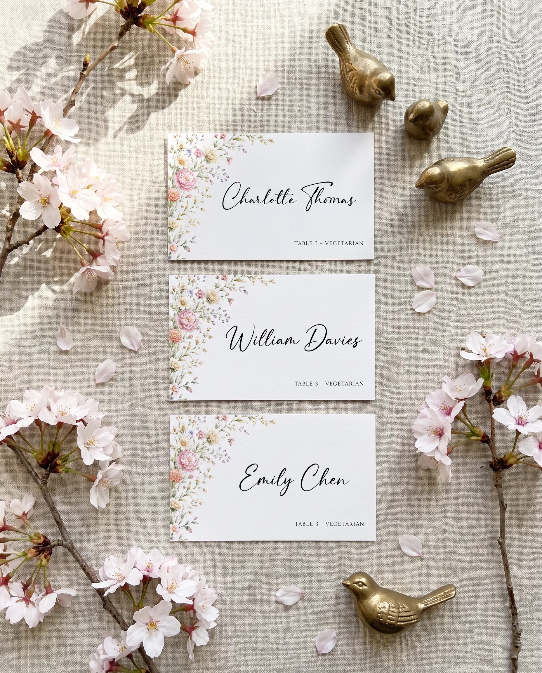 Petal Arbor wedding place cards — several place cards shown flat under soft natural light on premium editorial paper, wedding place cards.