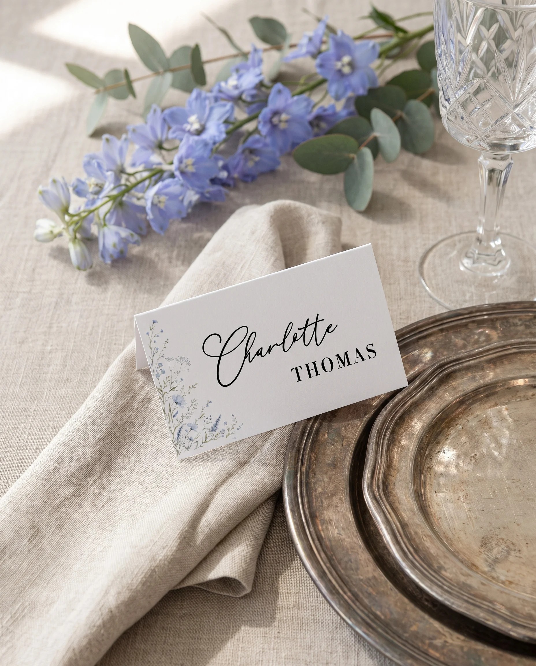Azure Sprig wedding place cards — a single card at a set place setting under soft overhead natural light, wedding name cards.