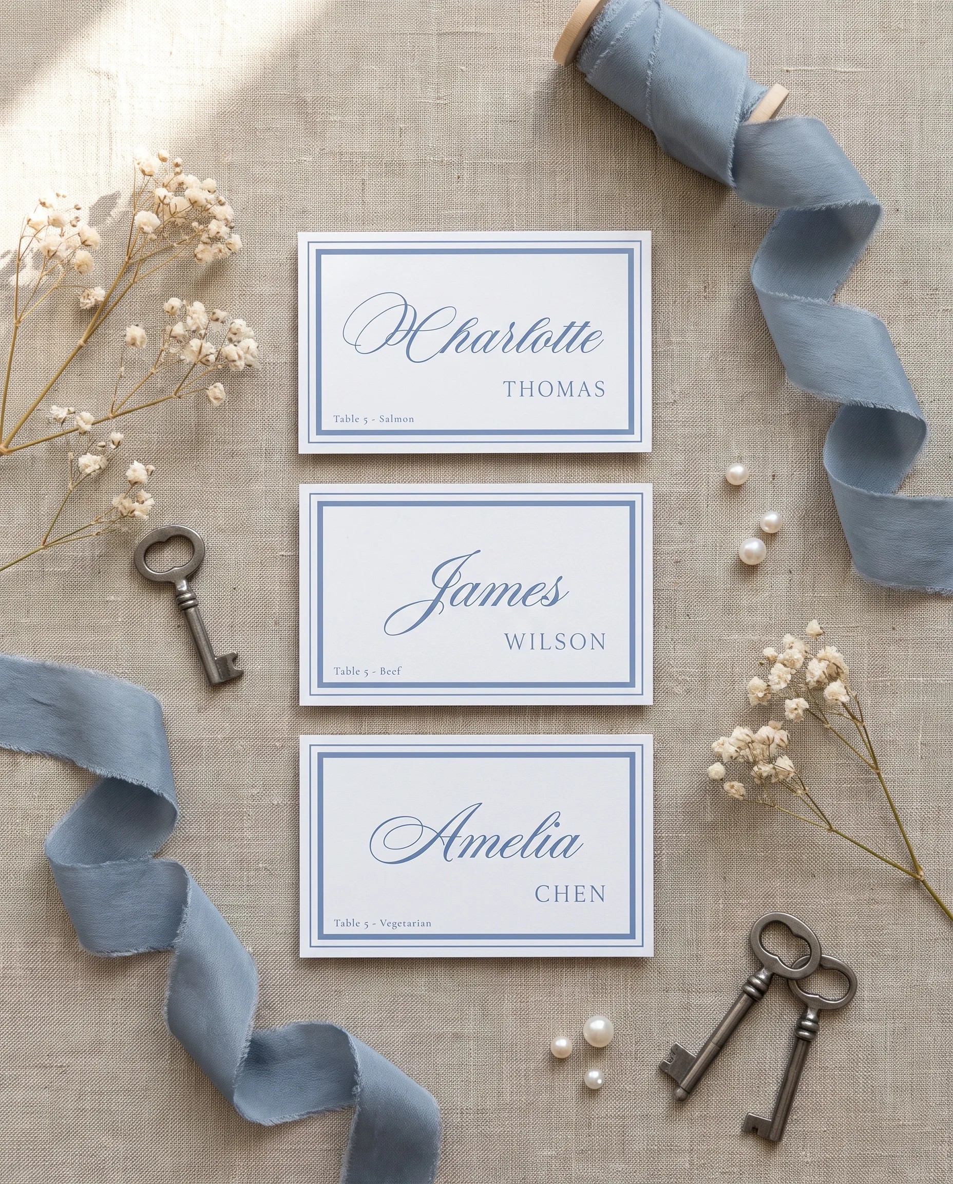 Azure Flourish wedding place cards — several cards shown flat under soft natural light with a slight overhead angle, wedding place cards