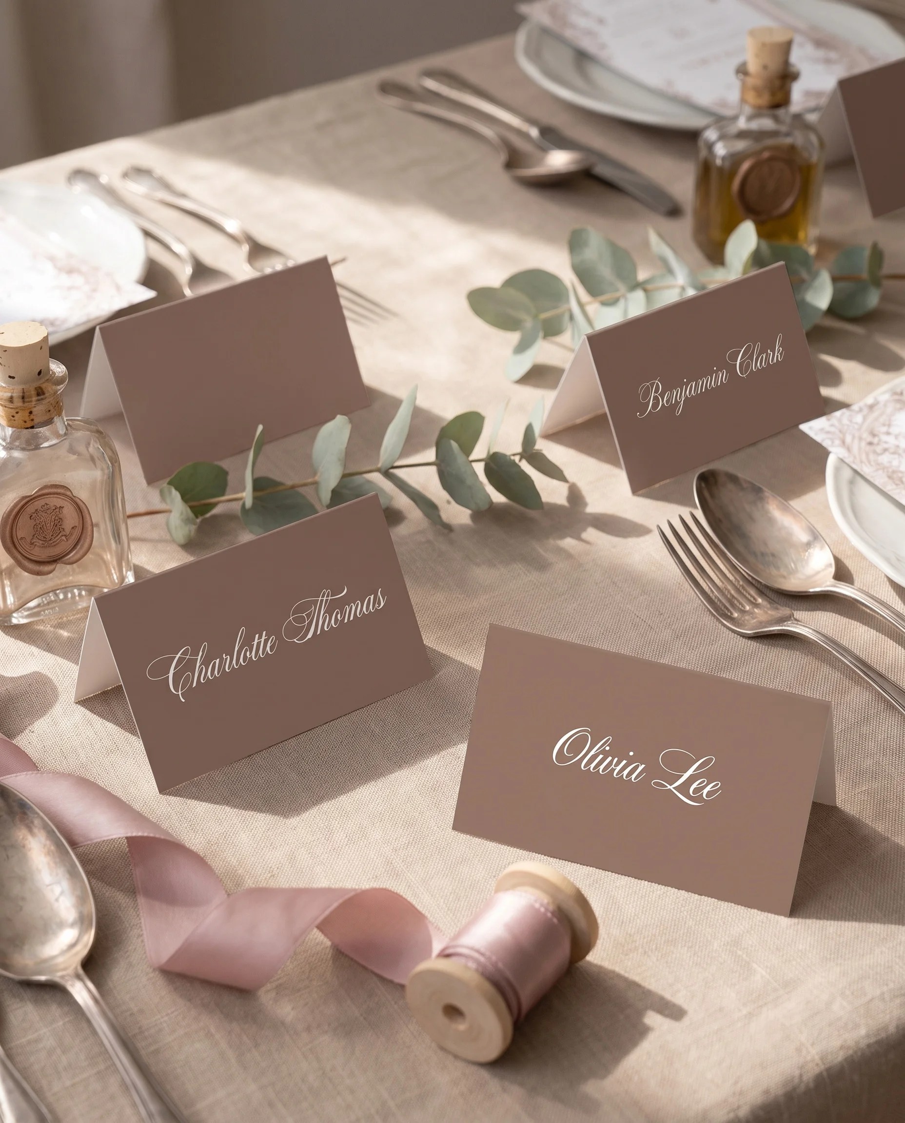 Hinge Script wedding place cards — several cards arranged on a dressed reception table under soft natural light, place card template.