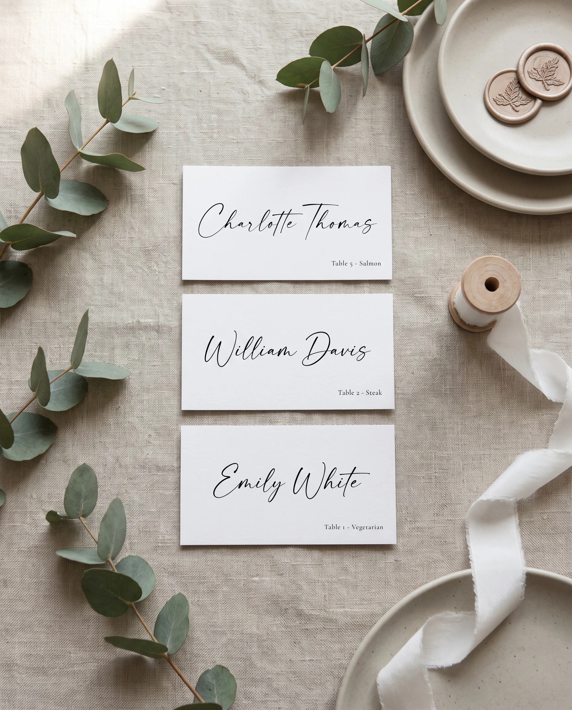 Arcadia wedding place cards — several place cards shown flat in an overhead view under soft natural light, wedding place cards.