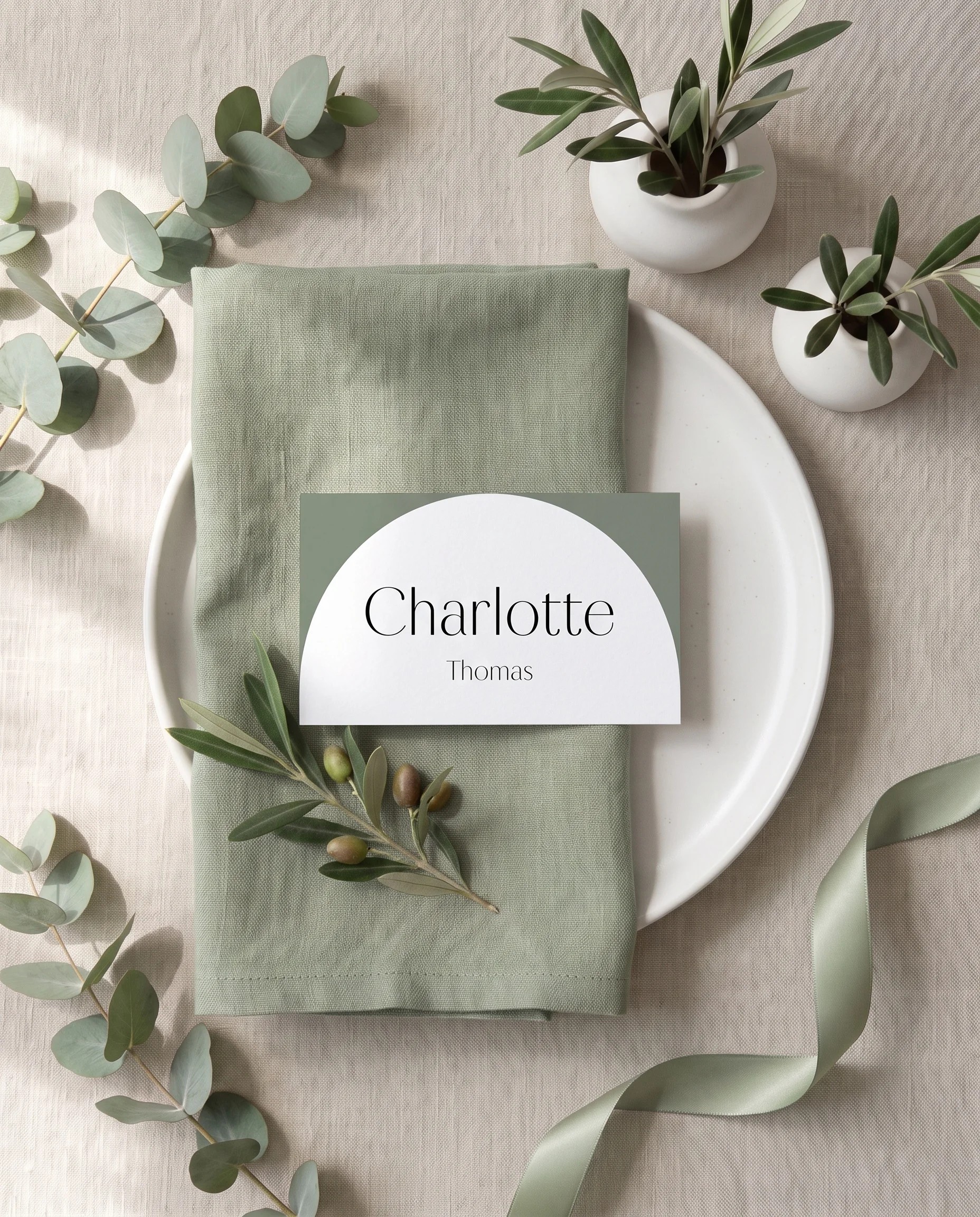 Arc Vale wedding place cards — a single card at a set place setting under soft overhead natural light, wedding name cards.