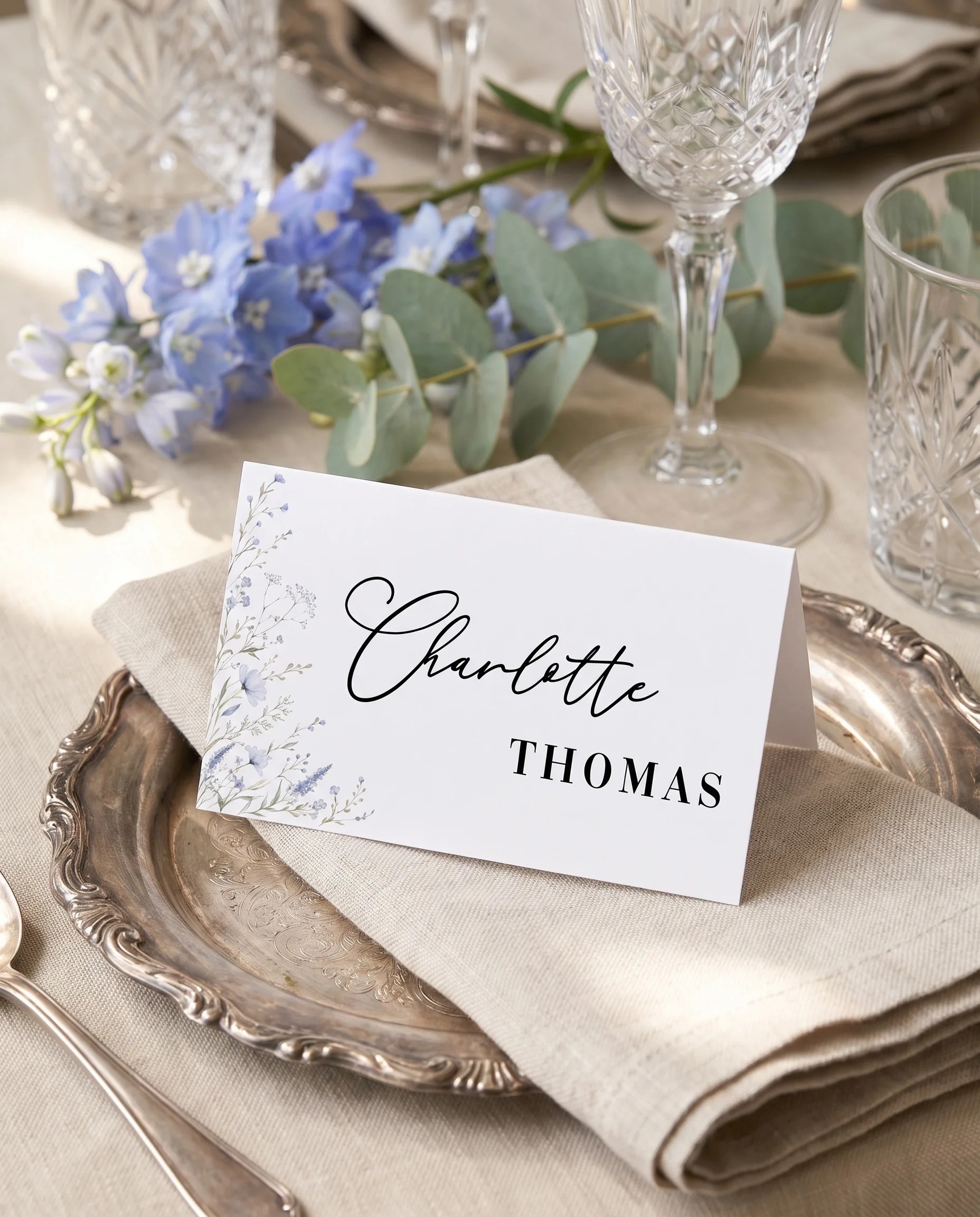 Azure Sprig wedding place cards — a single card at a set place setting under soft overhead light, wedding name cards