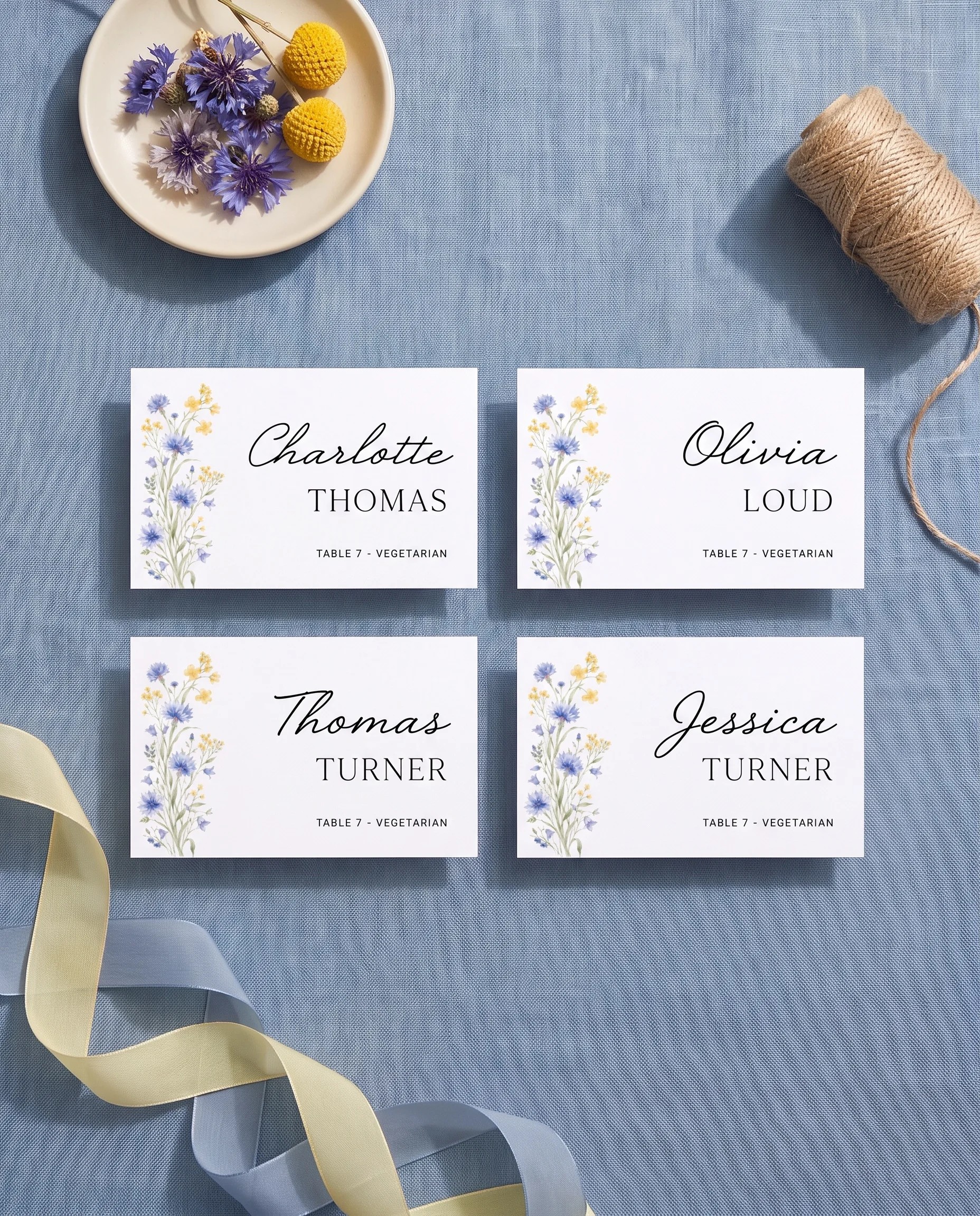 Cornflower wedding place cards — several place cards shown flat under soft natural light on premium editorial paper, wedding place cards