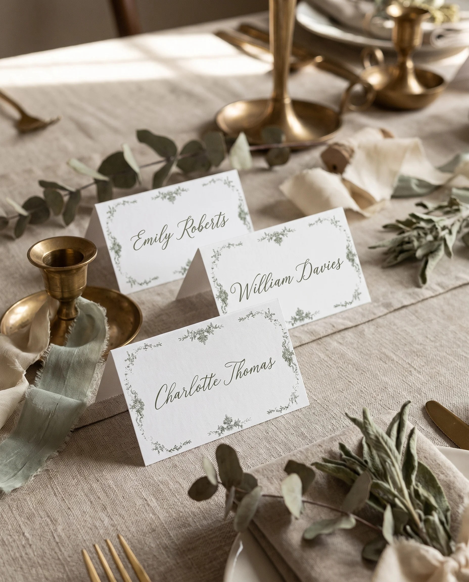 Sage Crest wedding place cards — several place cards arranged on a dressed reception table under soft natural light, place card template