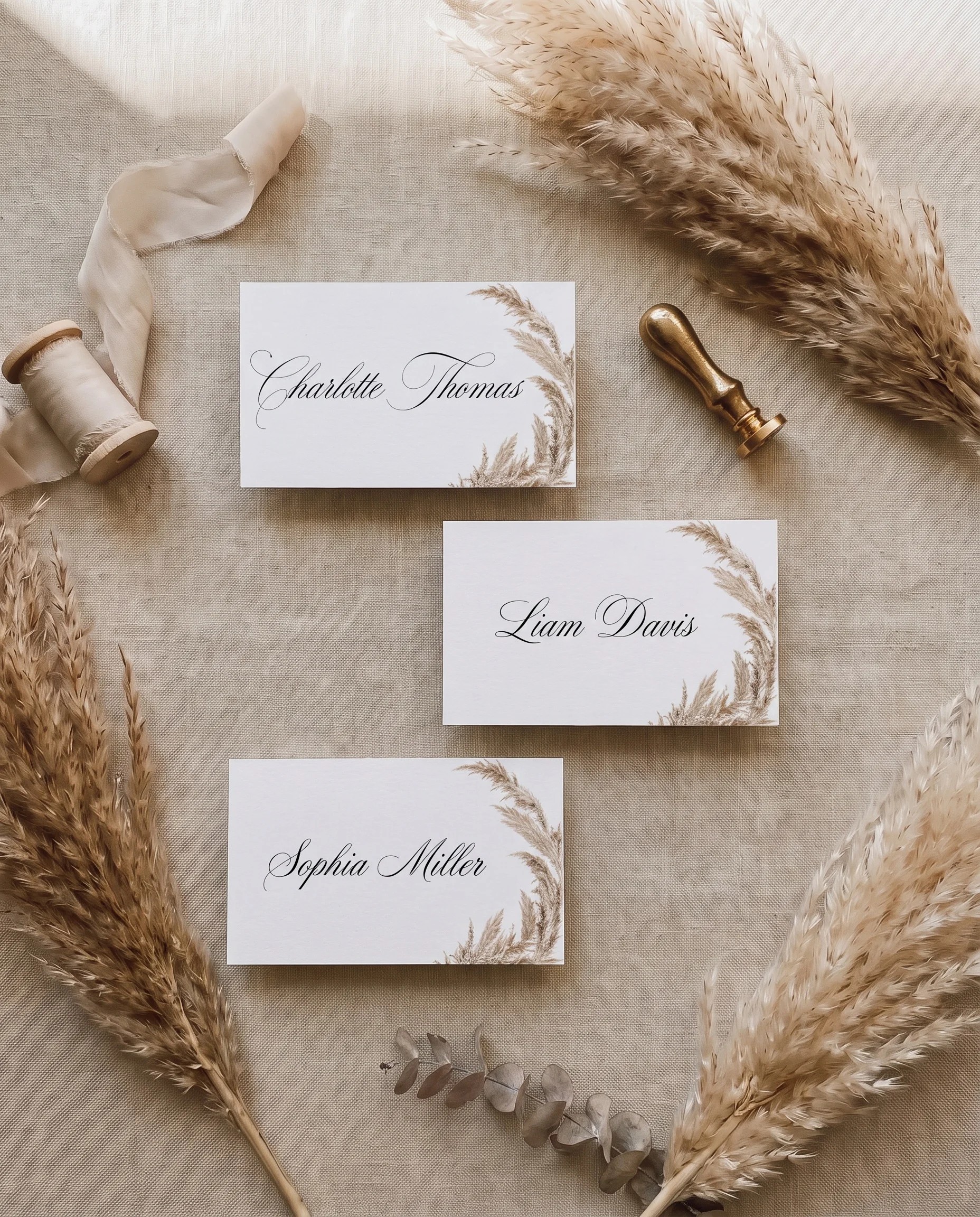 Pampas wedding place cards — several place cards shown flat in an overhead view under soft natural light, wedding place cards