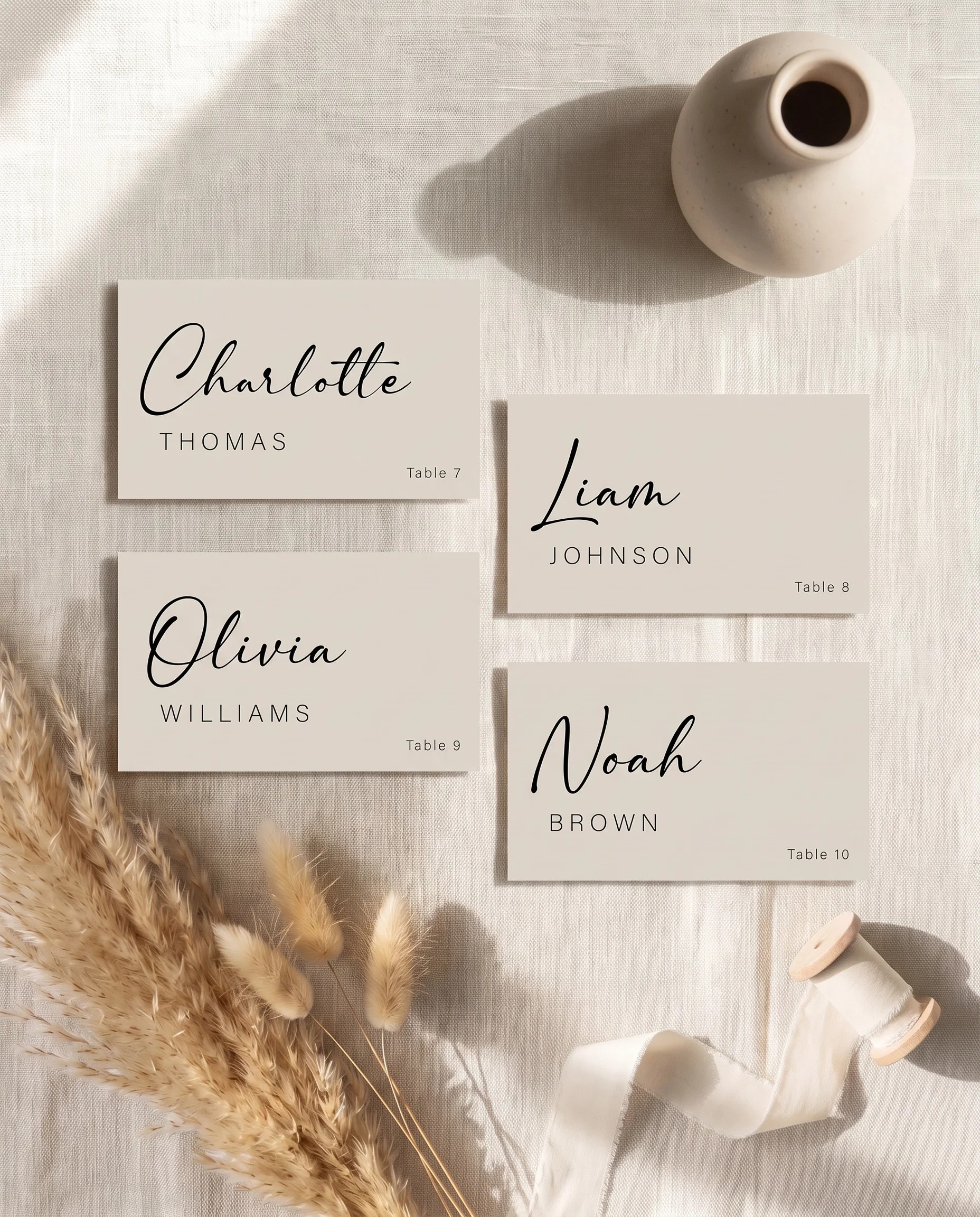 Tassel Arc wedding place cards — several cards shown flat lay under soft natural light at a slight overhead angle, wedding place cards