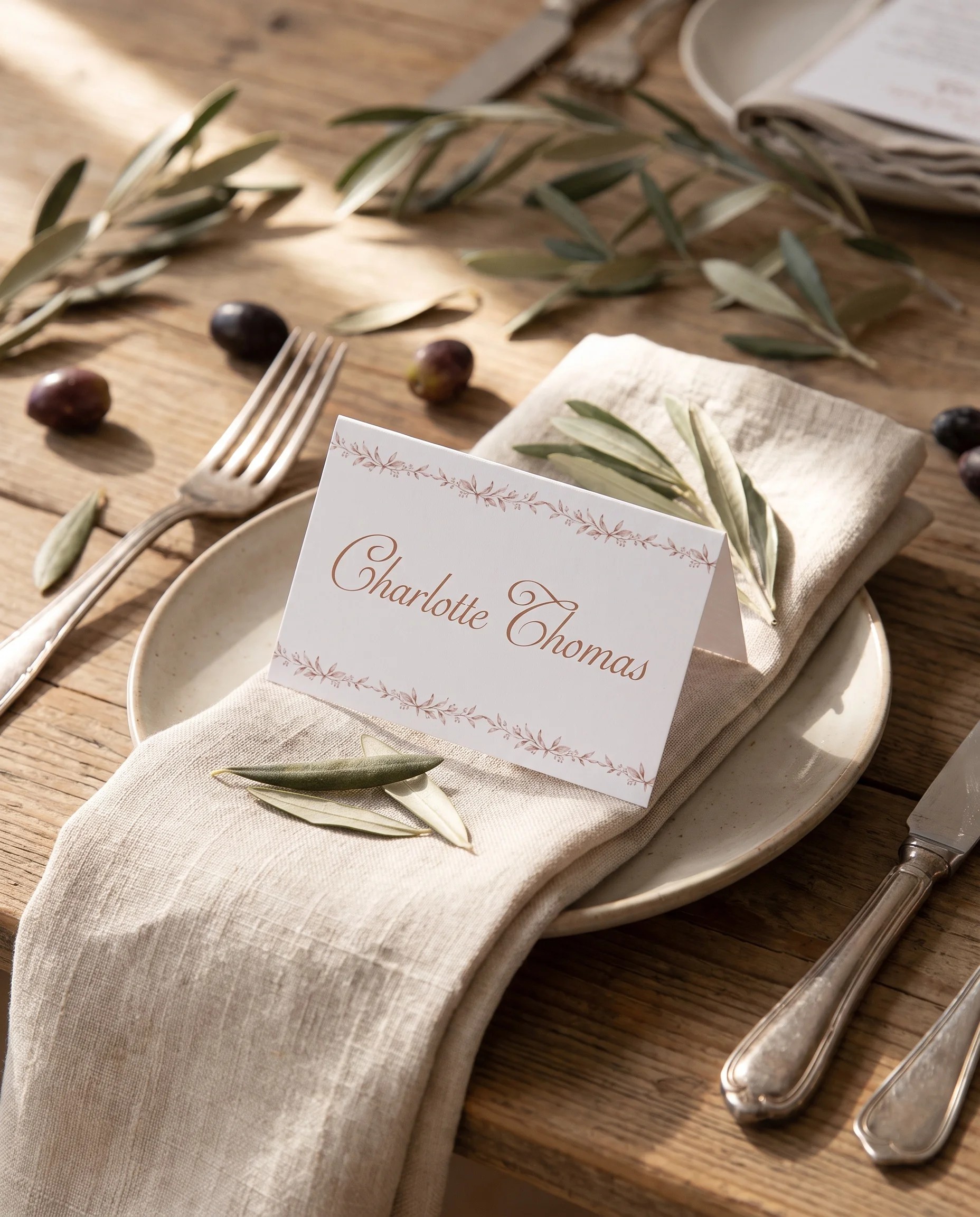 Sepia Sprig wedding place cards — a single card at a set place setting under soft natural light, wedding name cards.