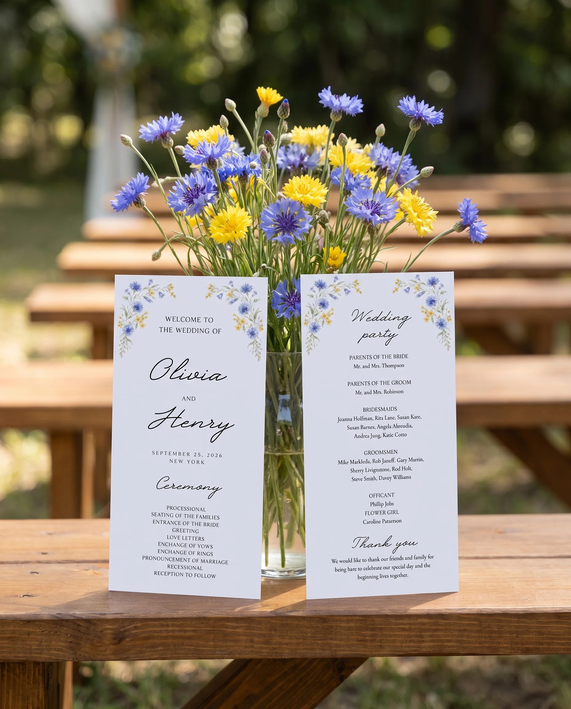 Cornflower wedding program — two flat card designs standing upright at a ceremony under soft natural light, wedding program template.