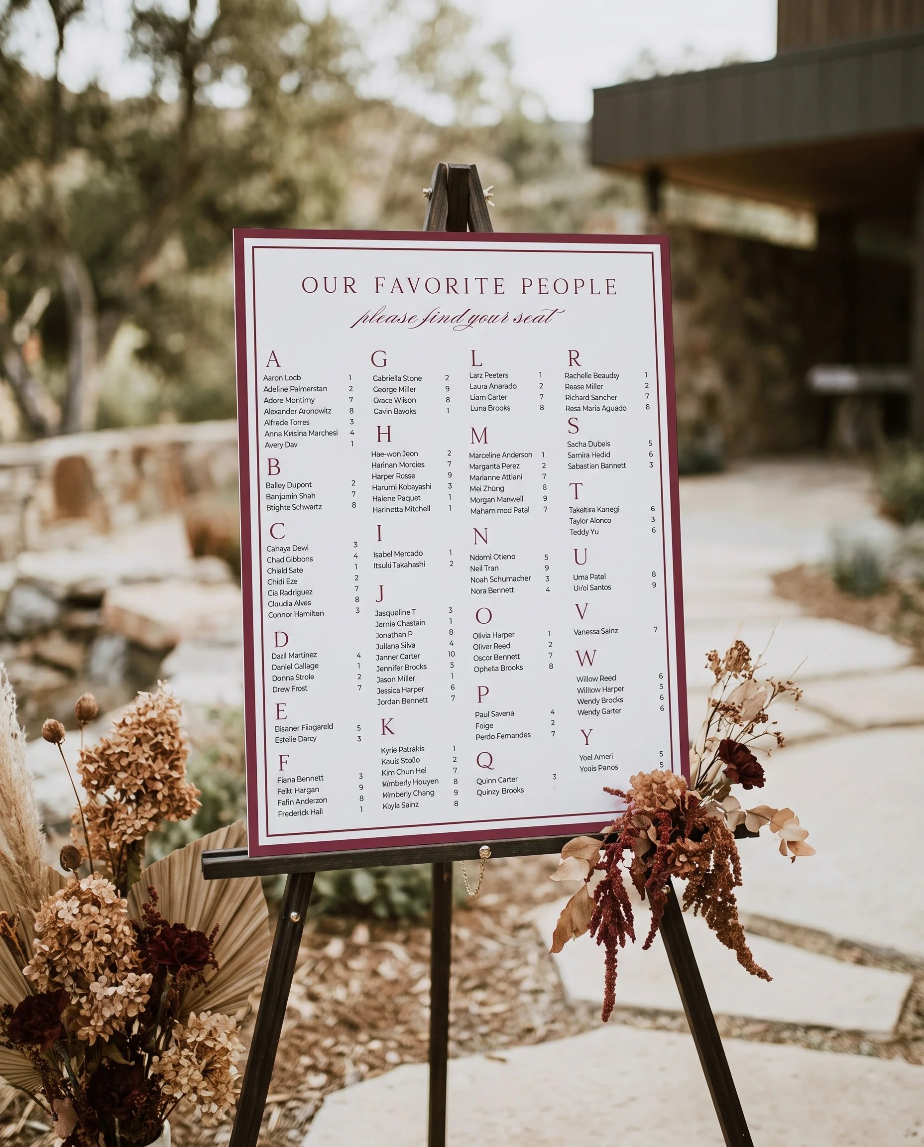 Claret Filigree wedding seating chart — single page displayed at a reception entrance under soft natural light, seating chart template