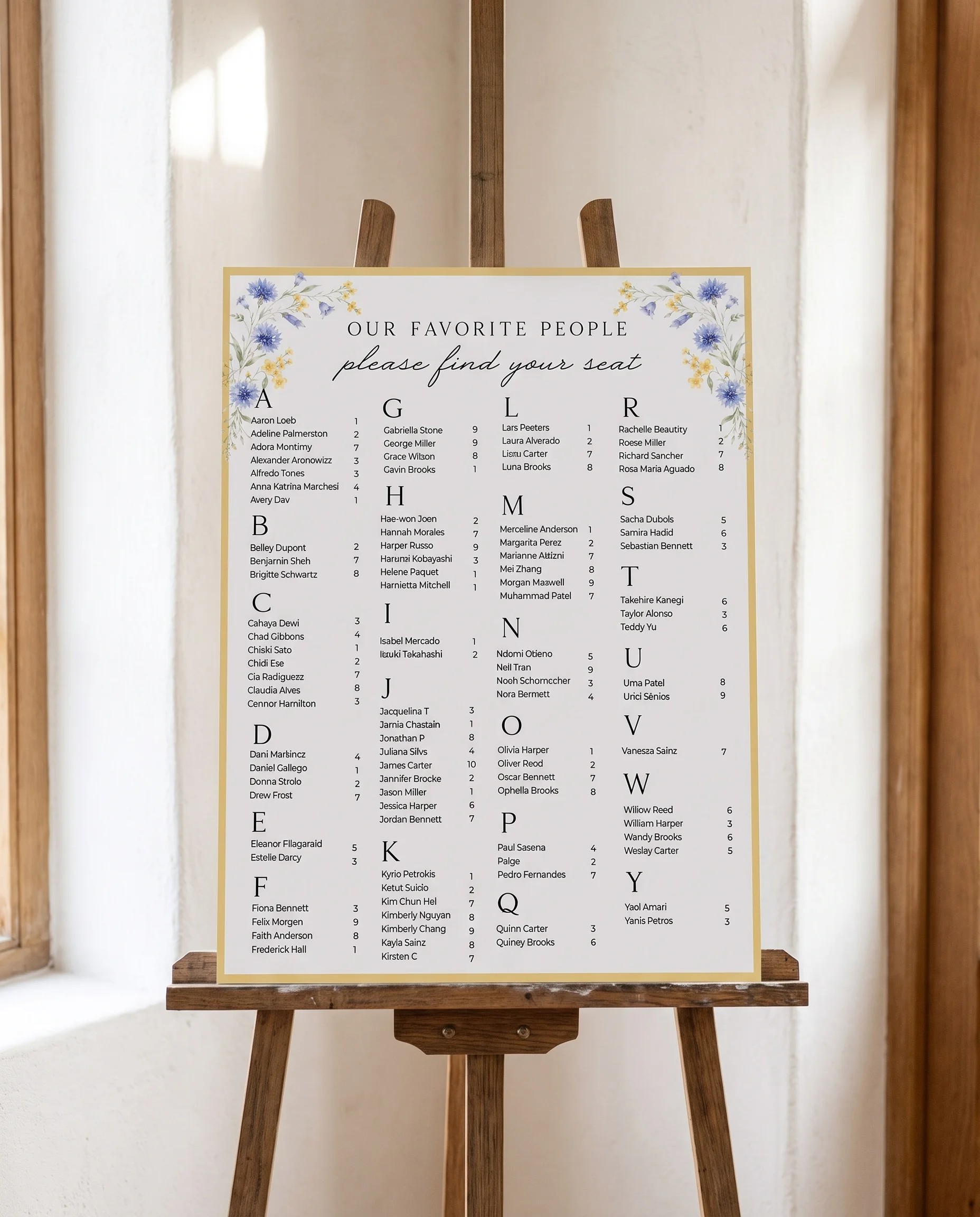 Cornflower wedding seating chart — displayed on an easel under soft natural light with a slight overhead angle, wedding seating chart