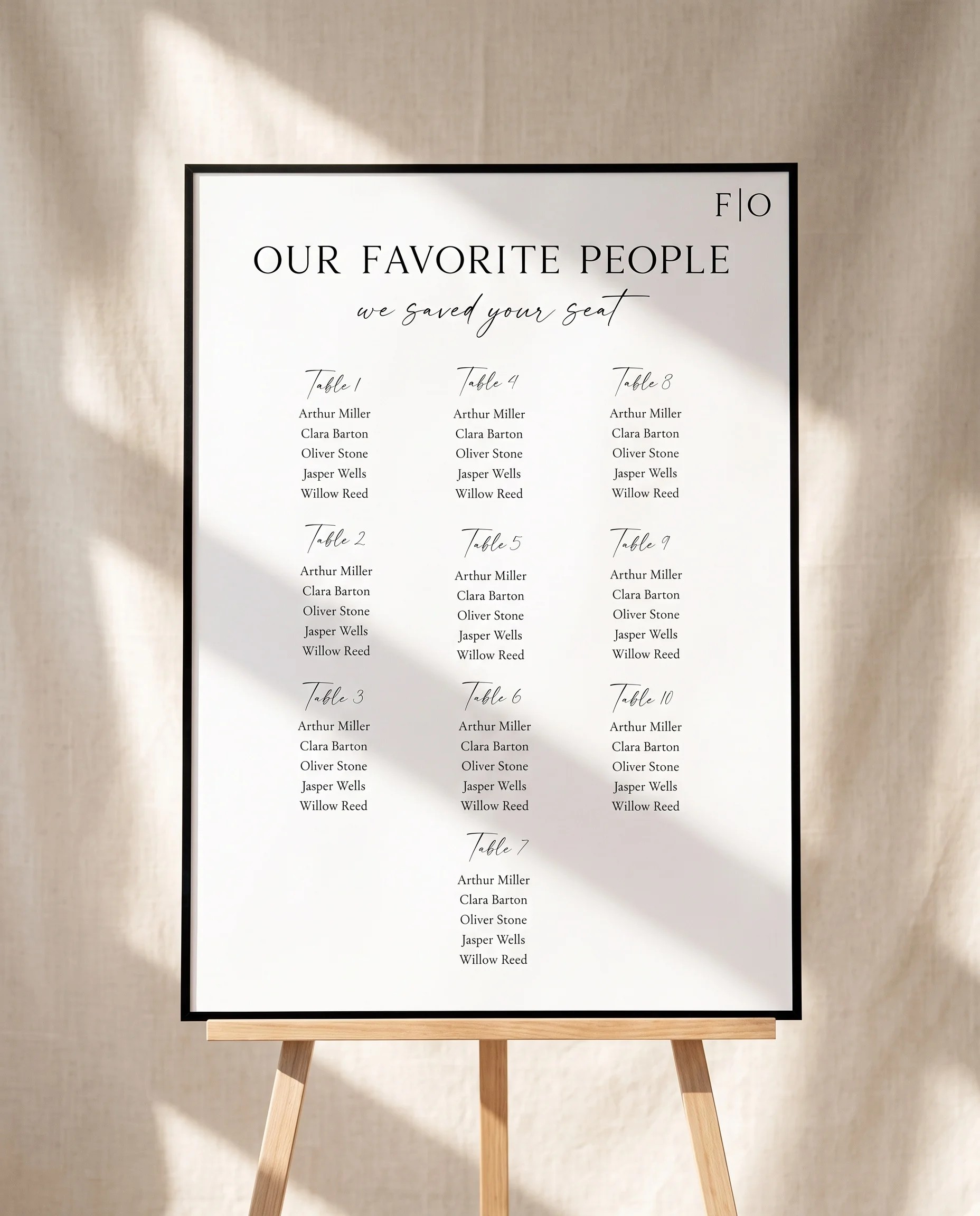 Lumen Frame wedding seating chart — displayed on an easel under soft natural light at a slight overhead angle, wedding seating chart.