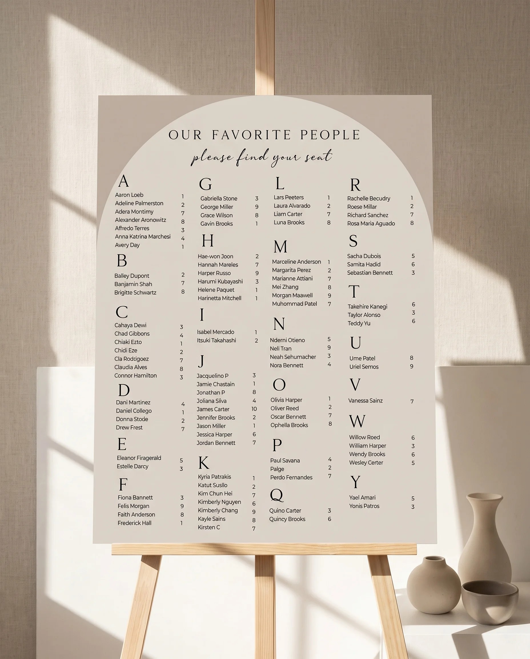 Tassel Arc wedding seating chart — displayed on an easel under soft natural light with a slight overhead angle, wedding seating chart.