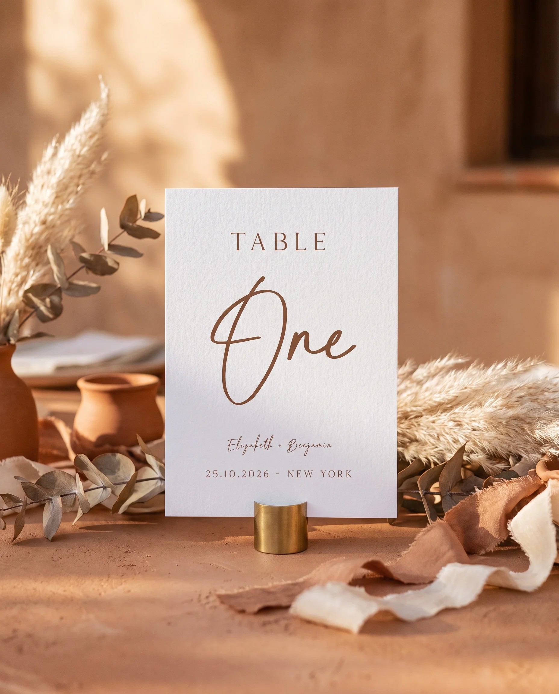 Briar Script wedding table number — standing upright on a dressed table under soft overhead light, table numbers wedding
