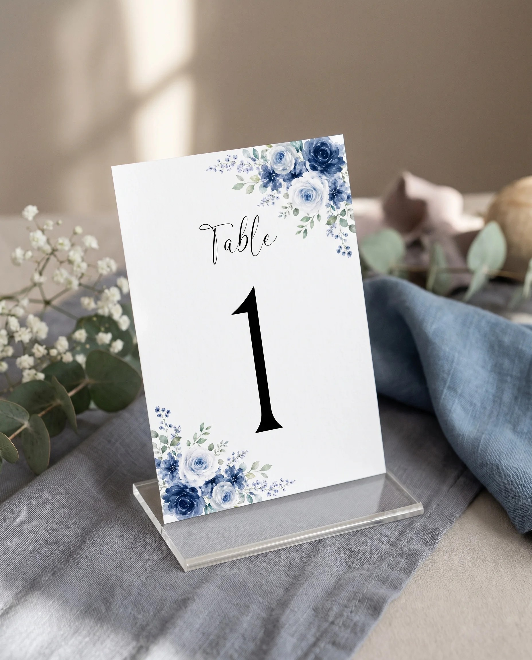 Bluebloom wedding table number — standing upright on a dressed table under soft natural light, premium editorial paper, table numbers wedding.
