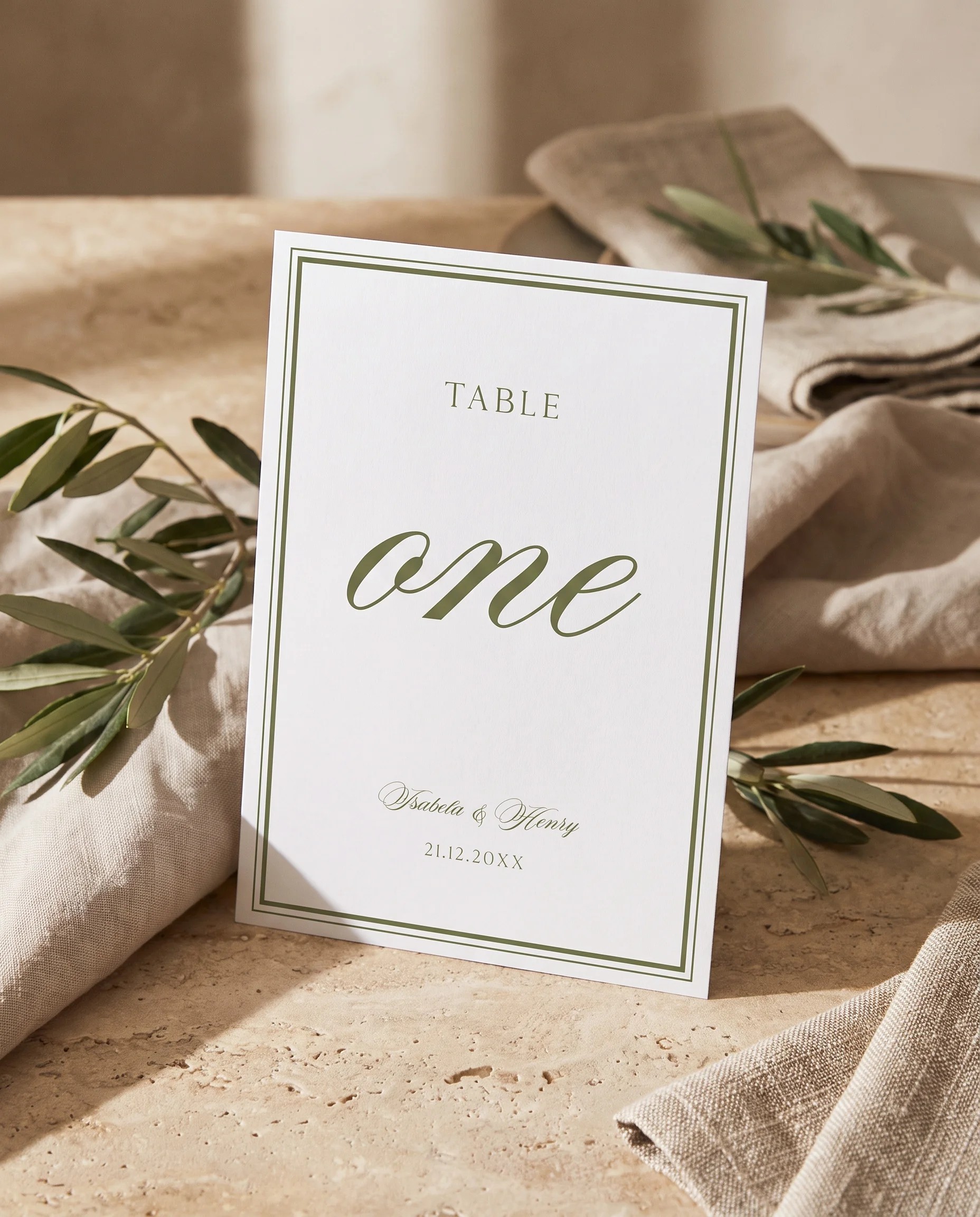 Olive Script wedding table number — standing upright on a dressed table under soft overhead natural light, table numbers wedding.