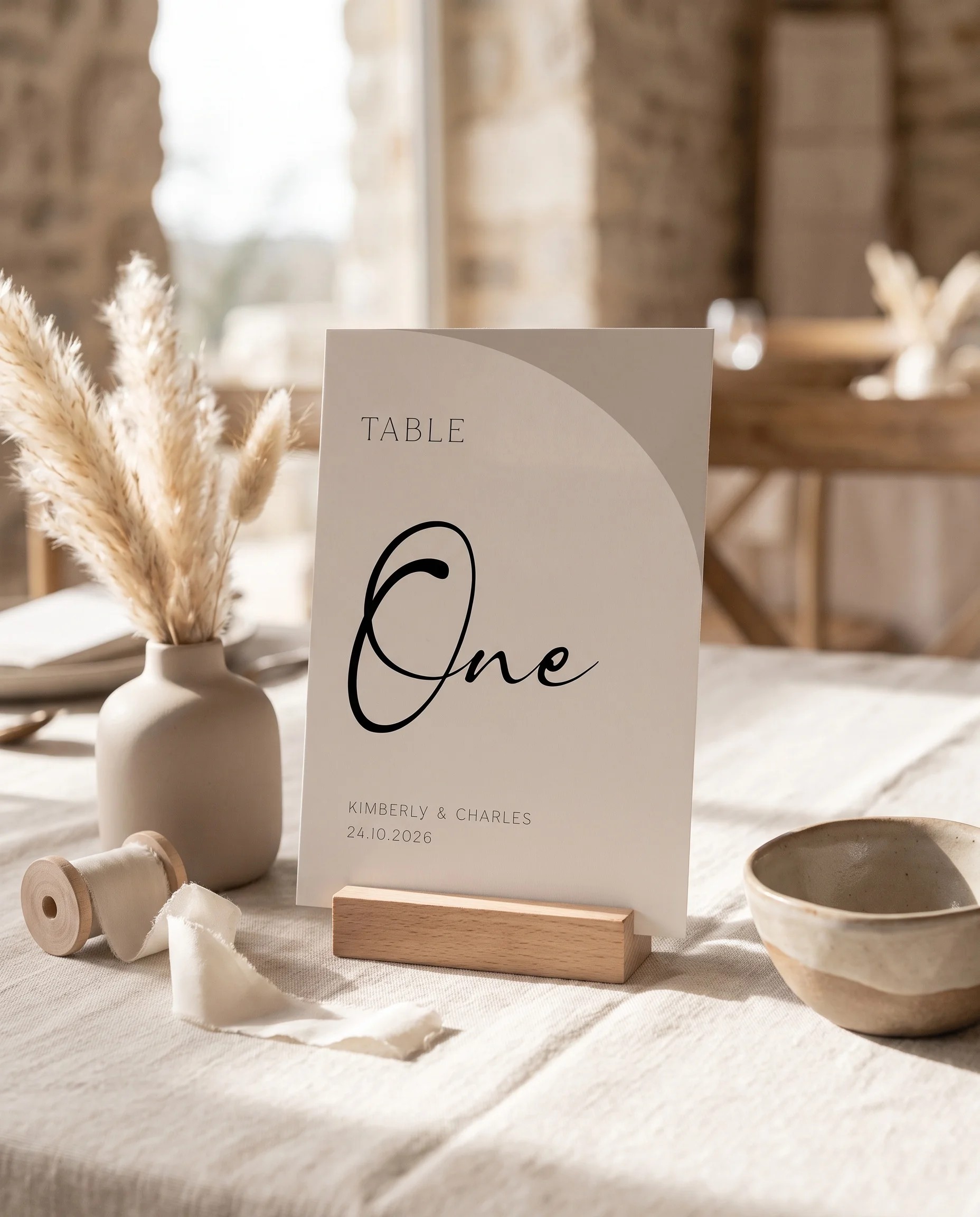 Tassel Arc wedding table number — standing upright on a softly lit, dressed table at a slight overhead angle, table numbers wedding